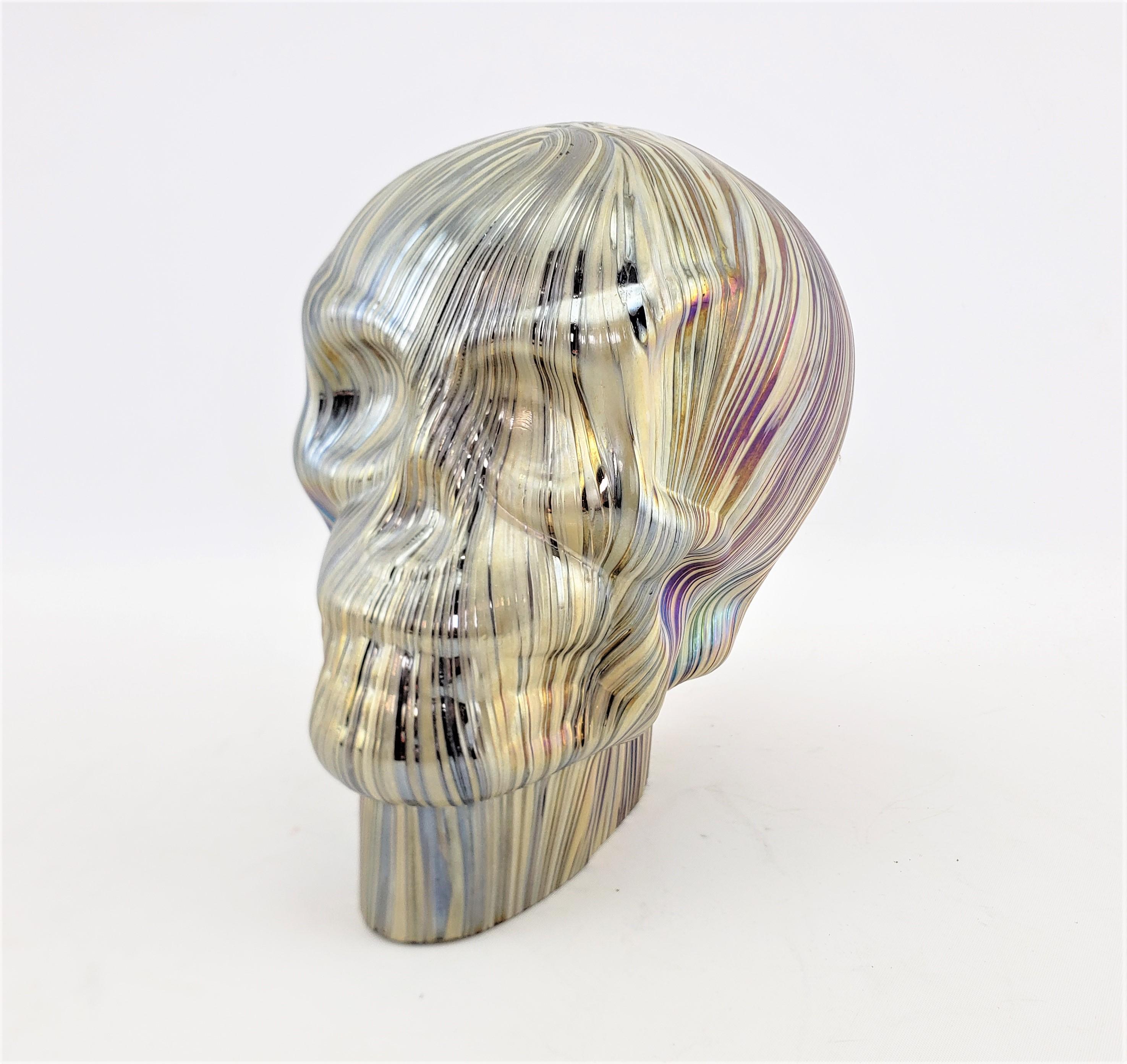 This art glass human skull is unsigned, but believed to originate from Europe, possibly Italy or the Czech Republic and date to approximately 1975 and done in a Mid-Century style. The skull is composed of a deep purple glass with a series of gold