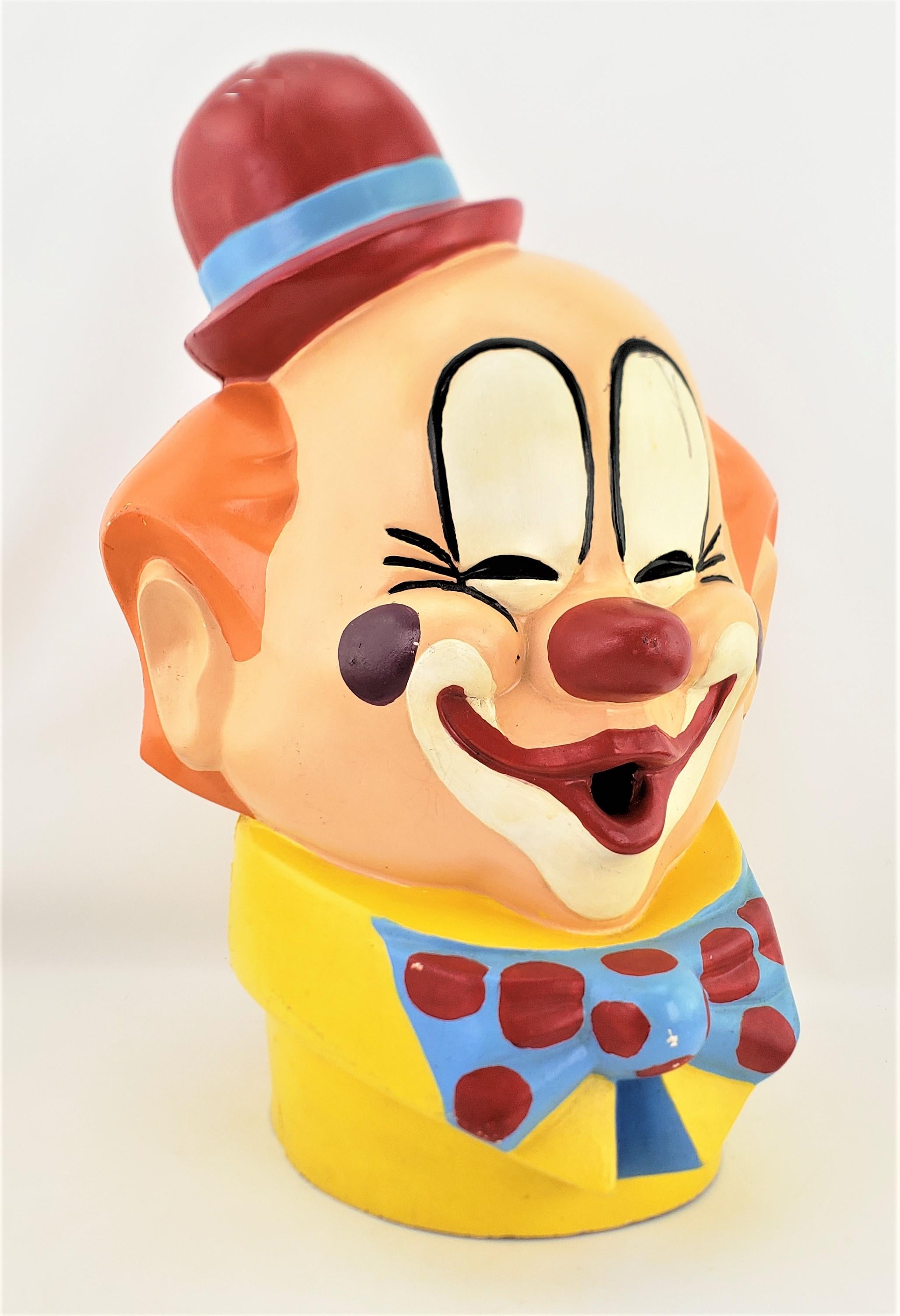 This whimsical clown head is unsigned, but presumed to have been made in Canada in approximately 1965 in the period Mid-Century carnival style. The head is composed of a molded fiberglass which has been cold-painted in very vibrant colors. This