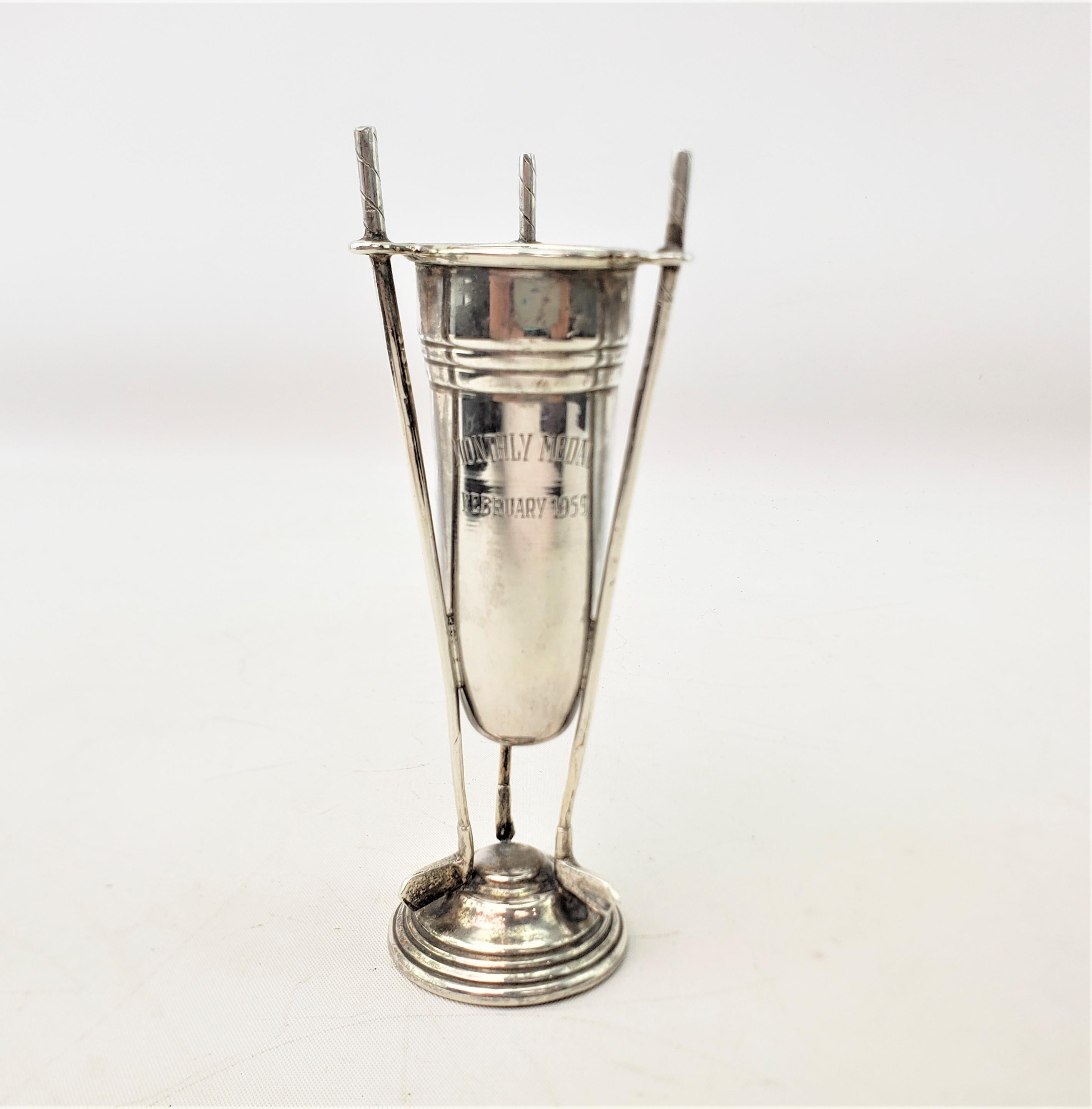 Diese Miniaturtrophäe im Vintage-Stil hat keine Herstellermarke, stammt aber vermutlich aus den Vereinigten Staaten und wurde etwa 1959 im Stil der Jahrhundertmitte gefertigt. Die Trophäe besteht aus Sterlingsilber und weist drei gegossene figurale