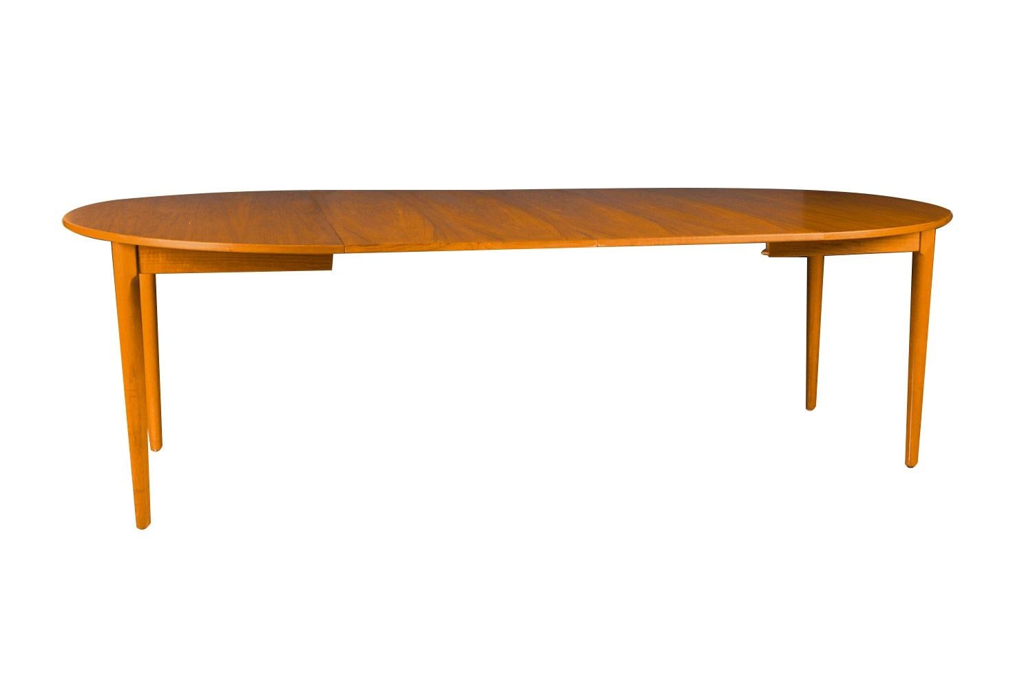 Beautiful Mid-Century Modern expandable teak dining table designed by Erik Buck and made by Povl Dinesen, manufactured in Denmark. Featuring richly grained, gleaming teak and smooth, clean lines characteristic of classic Danish design. Remaining in