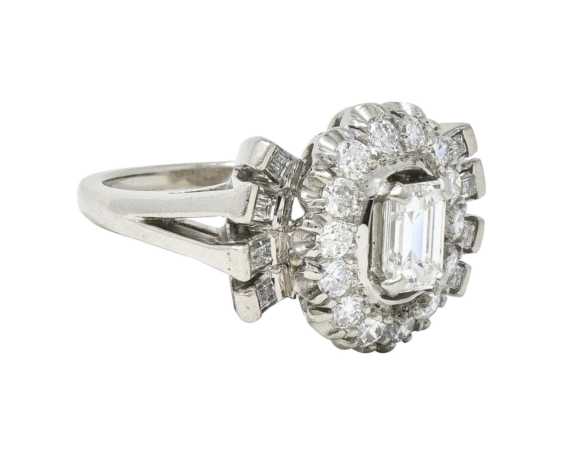 Centering an emerald cut diamond weighing approximately 0.63 carat - G color with VS2 clarity 
Set with wide prongs with a pierced floating halo surround of transitional cut diamonds
Weighing approximately 0.49 carat total - prong set in a wire