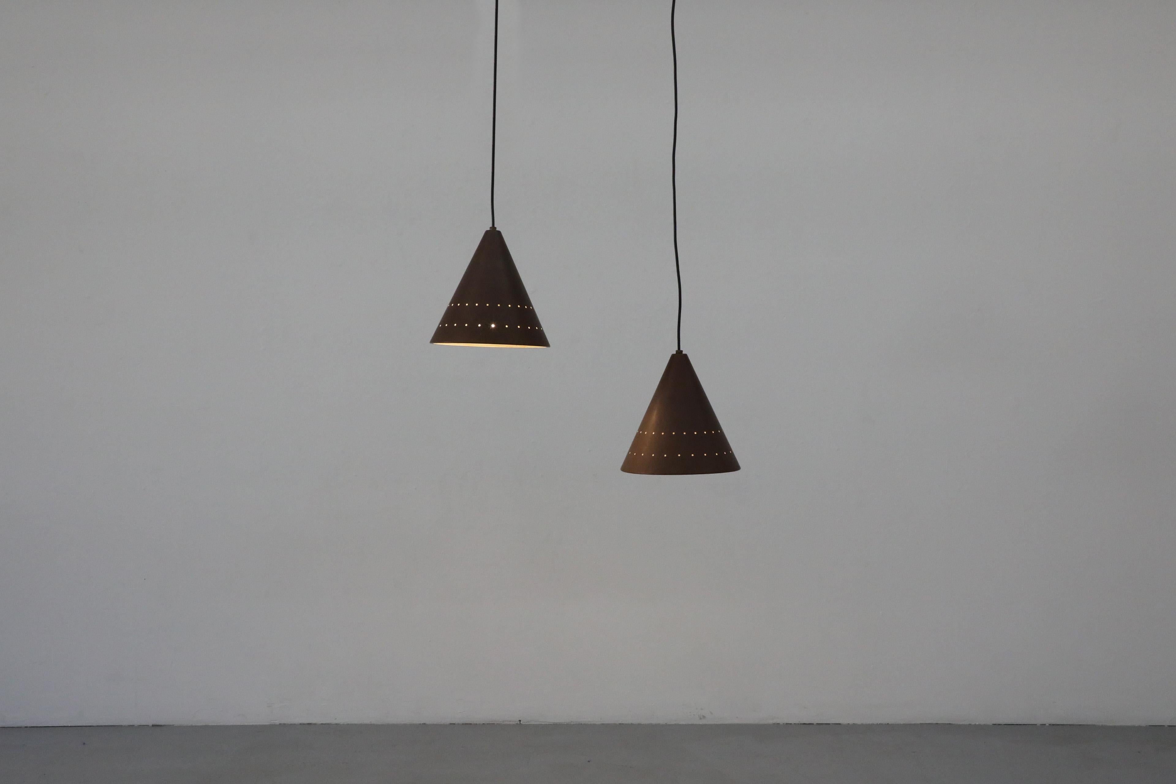 Mid-Century E.S. Horn Aalestrup attributed copper cone ceiling pendant lights with cut-out design around the bottom of each cone. In original condition with visible wear and patina consistent with their age and use, including scratching and