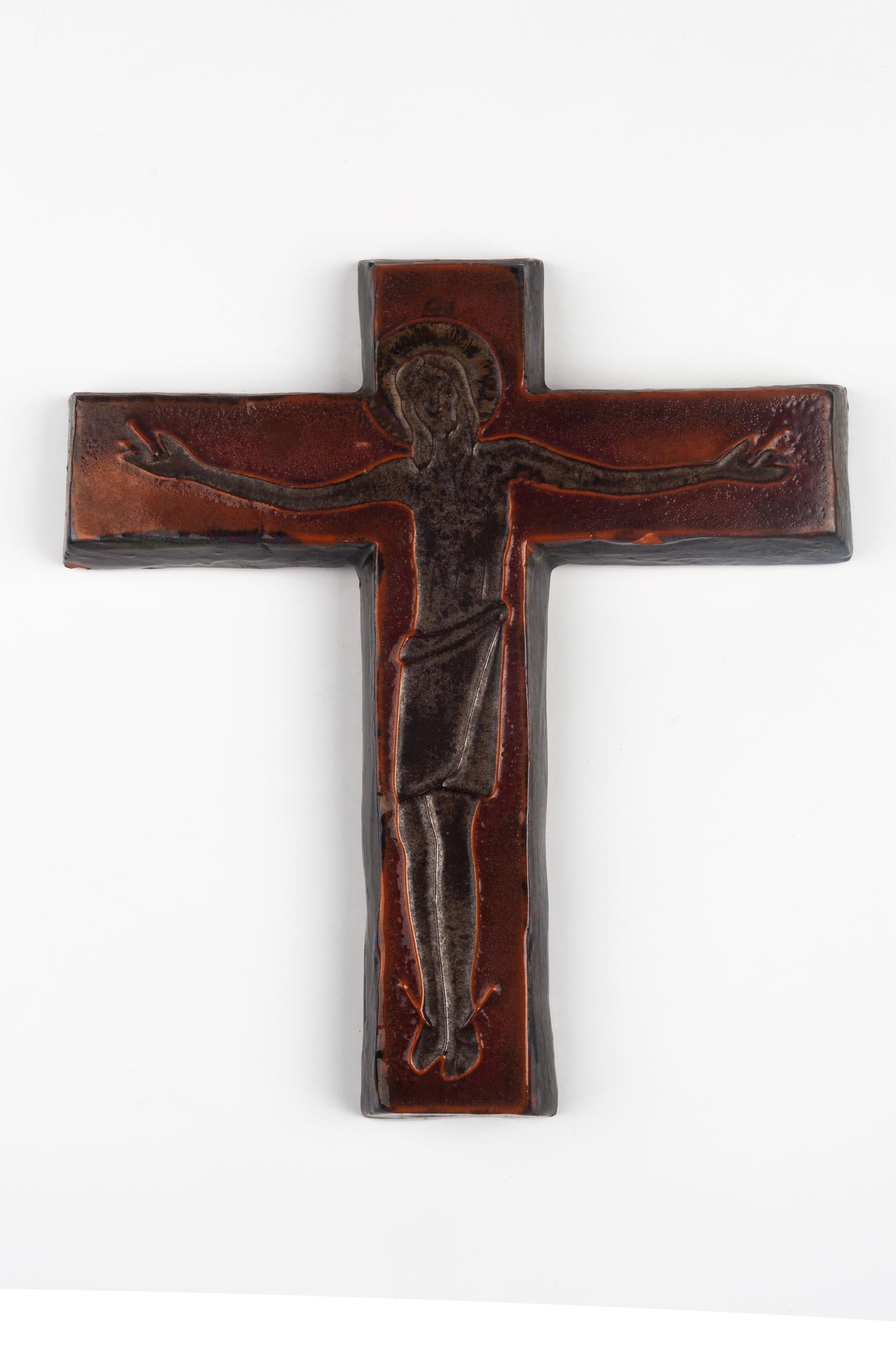 Dark rust tones of red and orange in this ceramic European wall crucifix glazed in semi-gloss. Christ figure realized in lined volumes . A one-of-a-kind, handcrafted piece that is part of a large collection of European crosses made by artisan