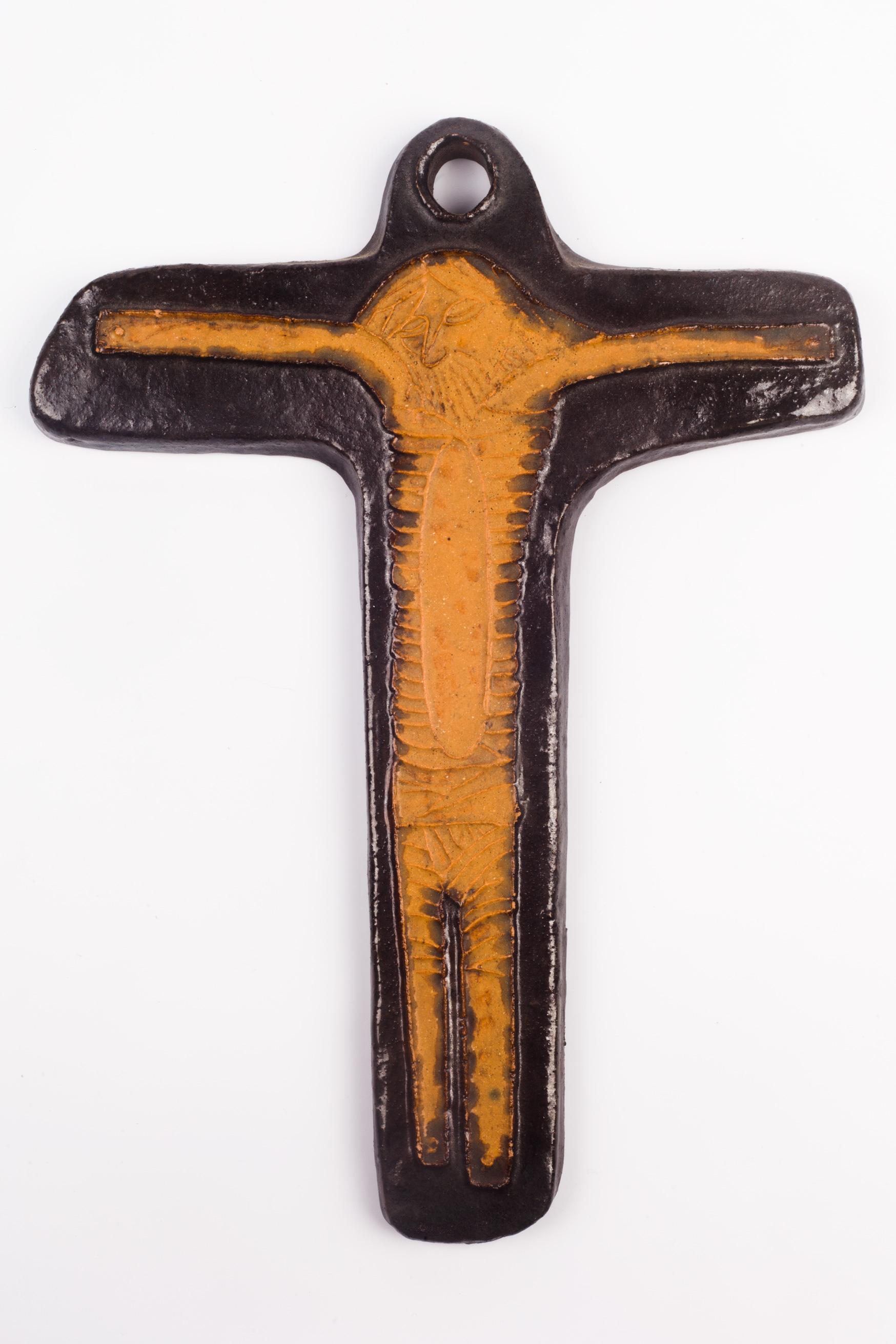 Early 1980s European crucifix hand-painted in matte and glossy earth colors. Brutalist, naive, and even outsider Christ figure embossed on a dark brown cross. A one-of-a-kind, handcrafted piece that is part of a large collection of crosses made by