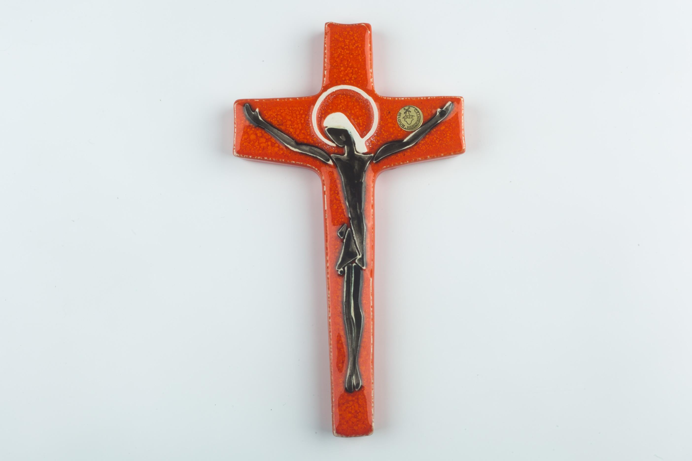 Large glossy brown ceramic wall cross, handmade in Europe in the 1960s. Asymmetrical cross shape with a figurative and textured Christ figure. A one-of-a-kind, handcrafted piece that is part of a large collection of crosses made by Belgian artisan