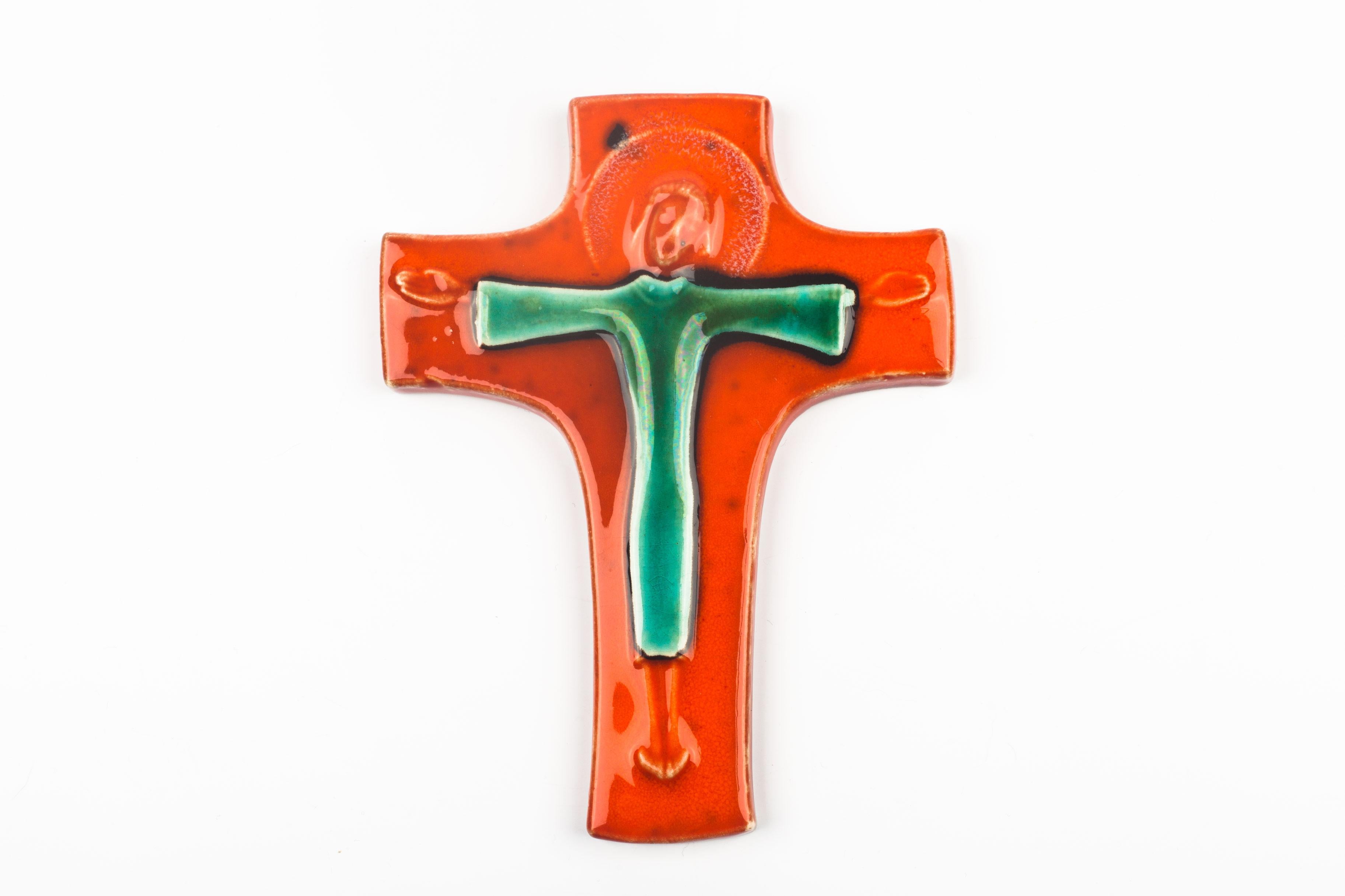 Mid-century, European ceramic crucifix. Hand-painted and glazed in bright orange, green, black and white with subtly raised christ figure at its center. A one-of-a-kind, handcrafted piece that is part of a large collection of crosses made by Belgian