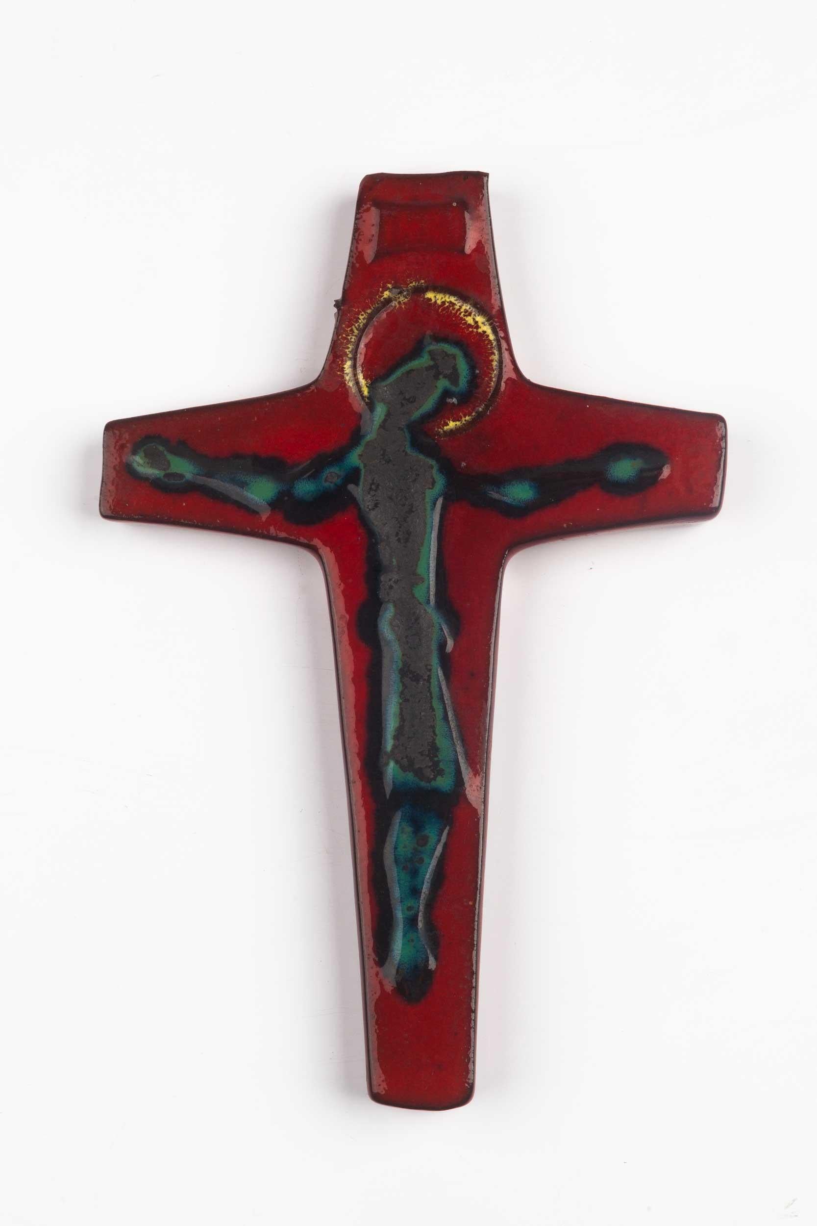 European mid-century crucifix in glazed ceramic, hand-painted in deep red and slate grey with mysterious christ figure and gold halo. A one-of-a-kind, handcrafted piece that is part of a large collection of crosses made by Belgian artisan potters
