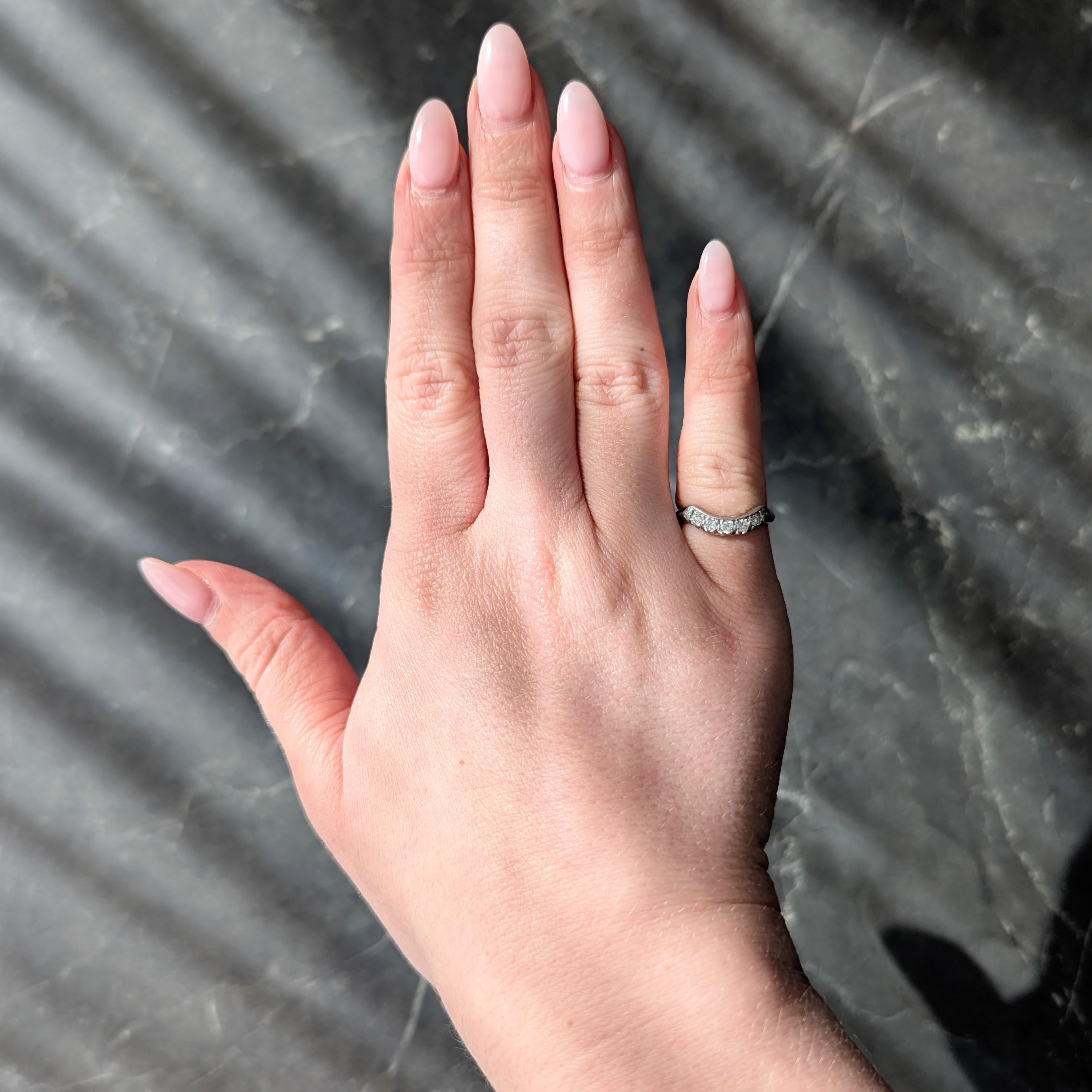 Con cinque diamanti taglio vecchio europeo incastonati a semicerchio sagomato
Peso totale di circa 0,40 carati - Colore H+I con purezza SI
Fiancheggiato da motivi di fiori d'arancio incisi
Accentuato da un profilo a coda di pesce con punte di