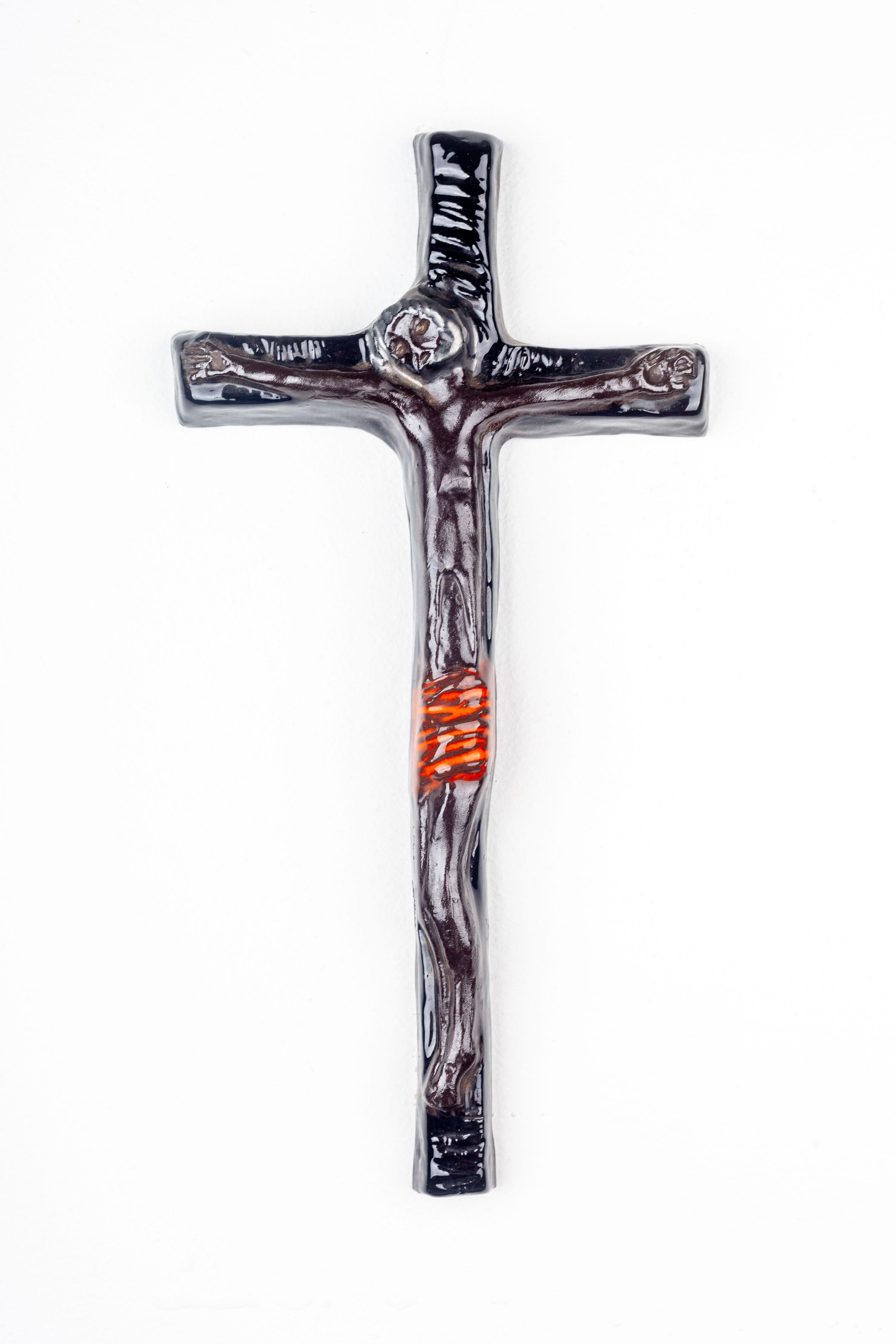 This wall cross is a representative work of mid-century European studio pottery, showcasing the era's distinctive approach to religious motifs. Handmade by studio artists, the cross combines the solemnity of religious art with the aesthetic
