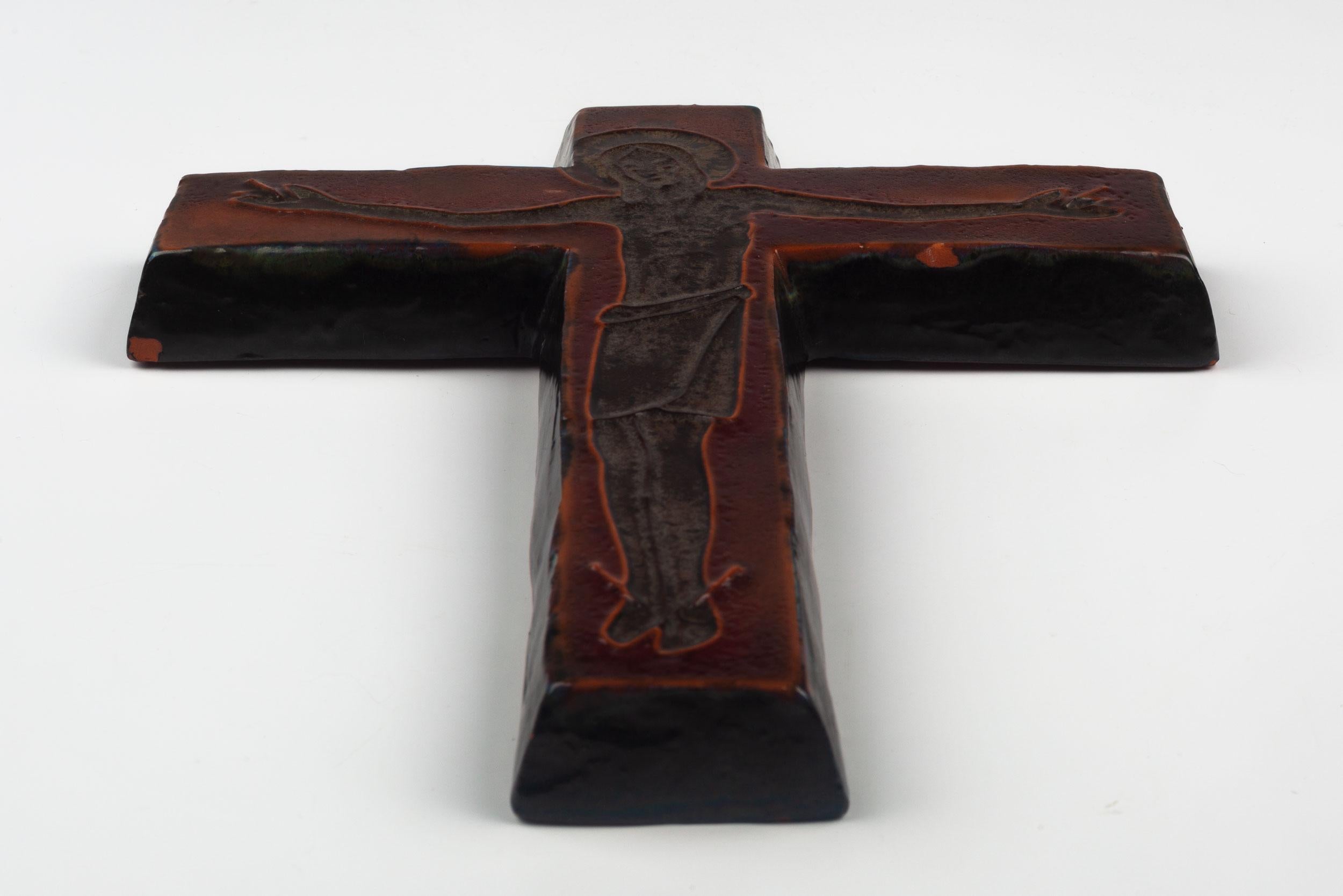 Midcentury European ceramic wall cross in sienna brown and black, with slight texture to the glazed ceramic and a mastery of depth of color. From a large collection of crosses handmade by Flemish artisans.

From modernism to brutalism, the crosses