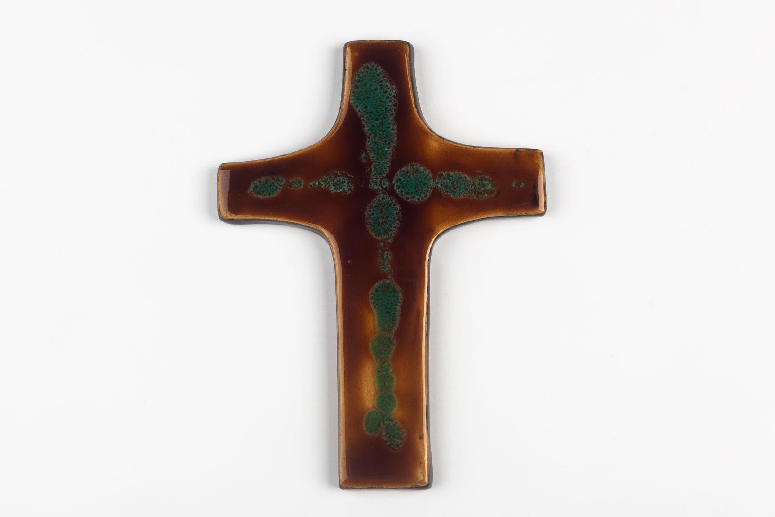 Mid-century European ceramic wall cross in brown and green, with slight texture to the glazed ceramic and a mastery of depth of color. From a large collection of crosses handmade by Flemish artisans.

From modernism to brutalism, the crosses in our