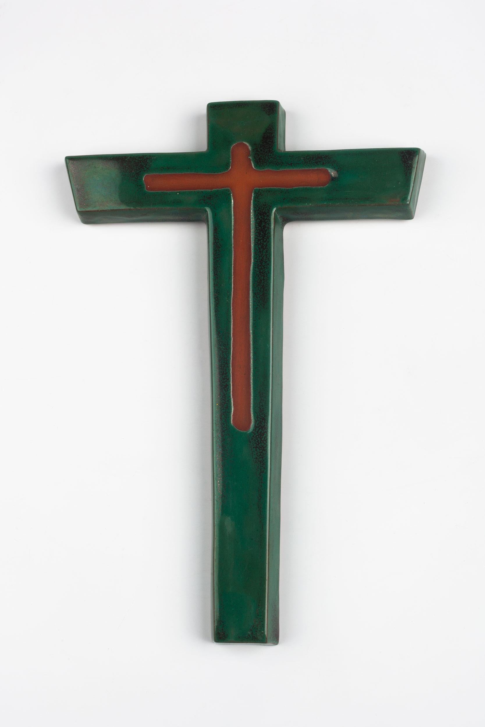 Midcentury European ceramic wall cross in matte brown and glazed green. From a large collection of crosses handmade by Flemish artisans.

From modernism to brutalism, the crosses in our collection range from being as futurist as a modernist church