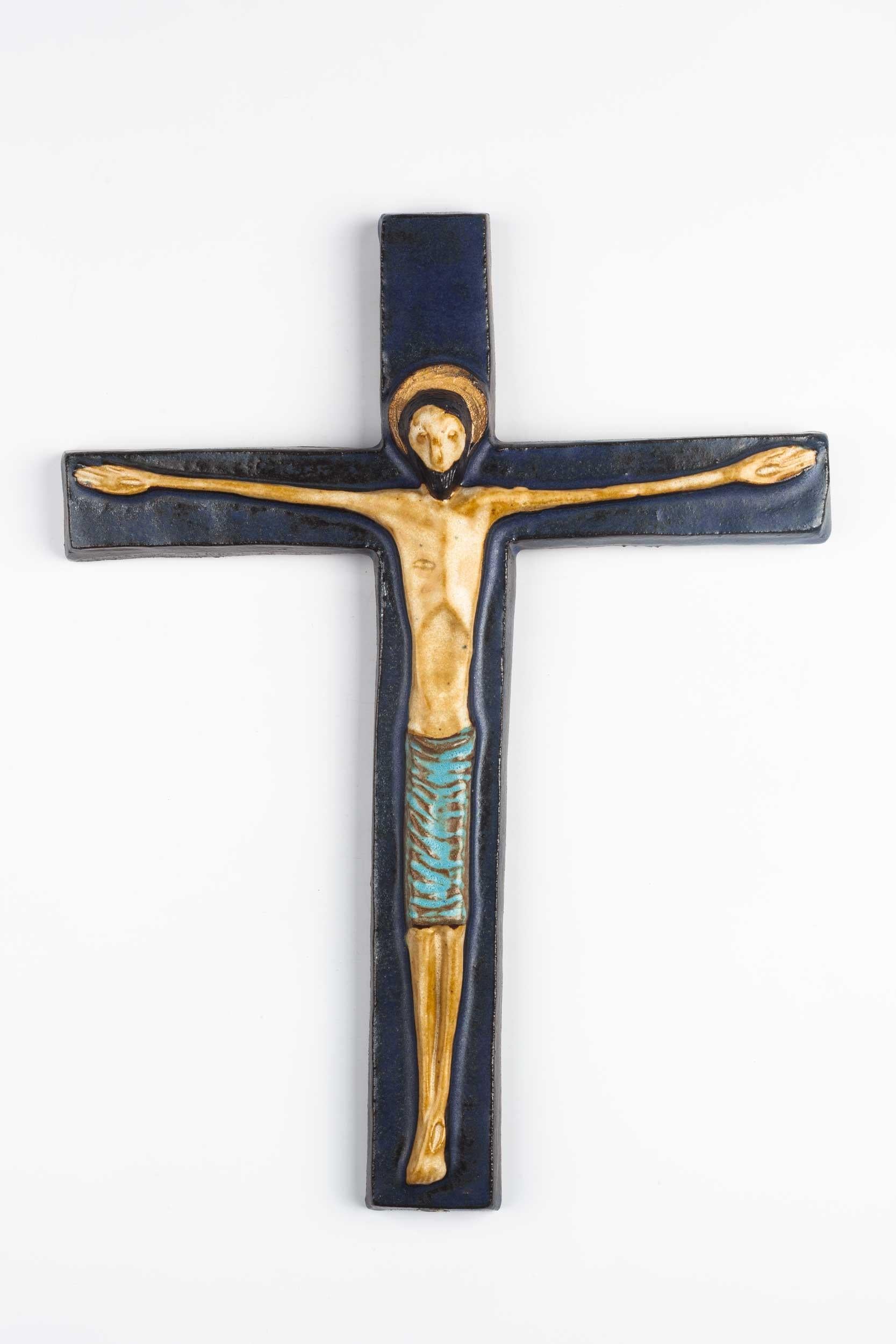 Midcentury European wall cross in dark and light blue with endearing christ figure in volume. From a large collection of vintage crosses handmade by Flemish artisans. 

From modernism to brutalism, the crosses in our collection range from being as