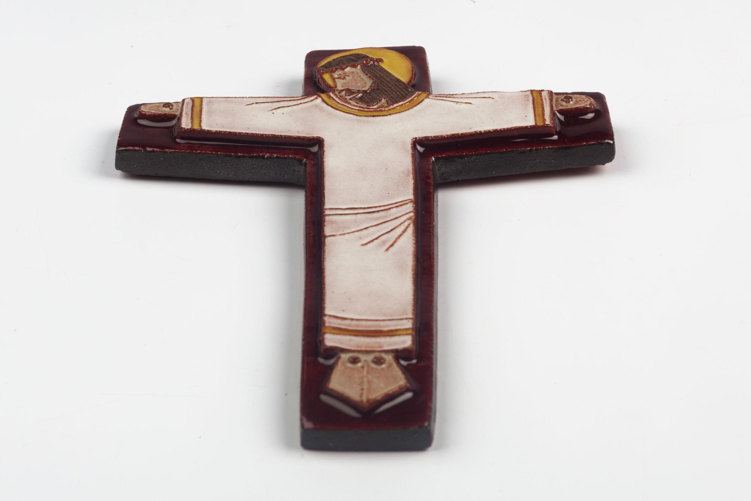 Mid-Century Modern, European crucifix in glazed ceramic, handmade made in Belgium in the 1970s. Red-brown, burgundy cross with yellow, white, brown raised christ figure at its center.

This piece is part of a large ceramic crucifix collection, all