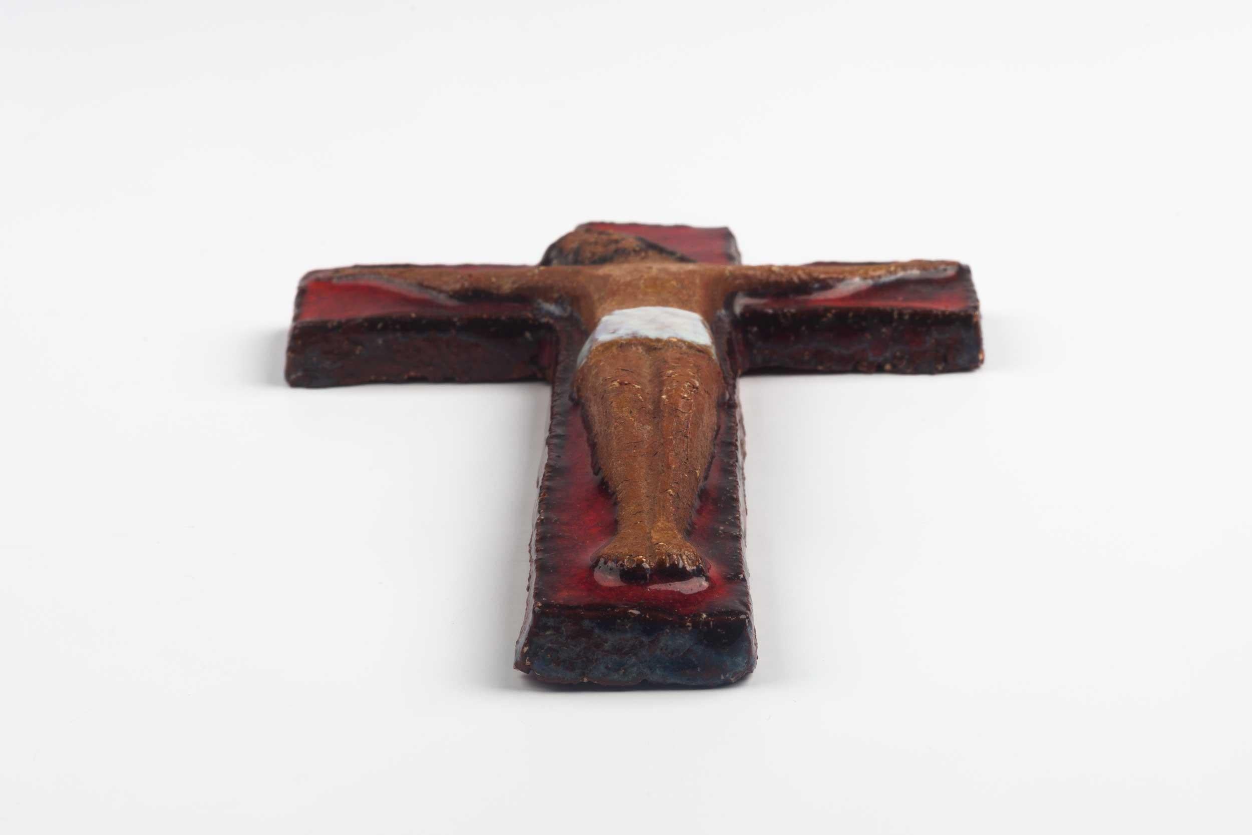 Midcentury European wall cross in glazed red paint and natural red clay Christ figure in relief. From a large collection of vintage crosses handmade by Flemish artisans.

From modernism to brutalism, the crosses in our collection range from being