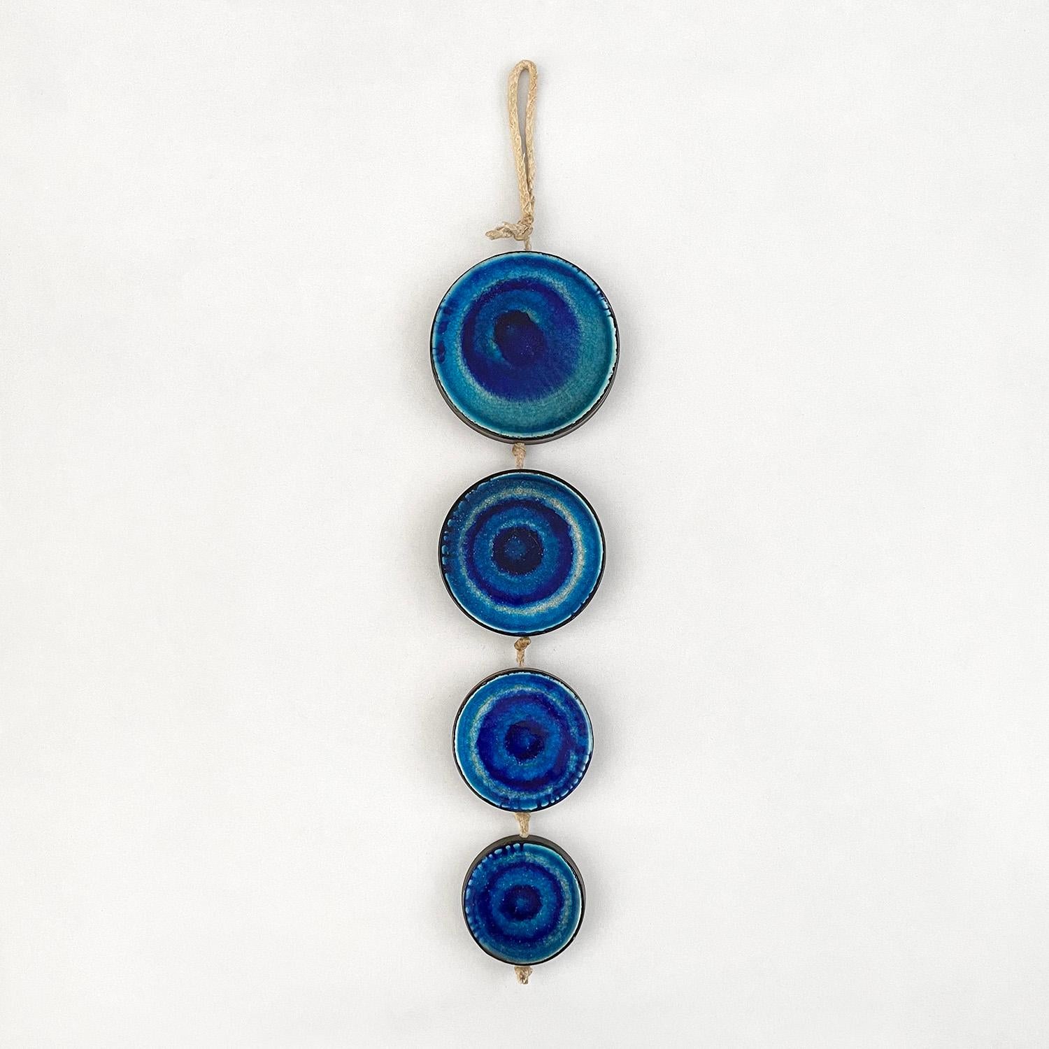Ceramic disc wall sculpture
Germany, circa 1960’s
Beautiful statement piece
Four unique ceramic discs with concentric rings
Rich color palette ranging from deep blues to light turquoise
Original rope cording with light surface markings
Patina from