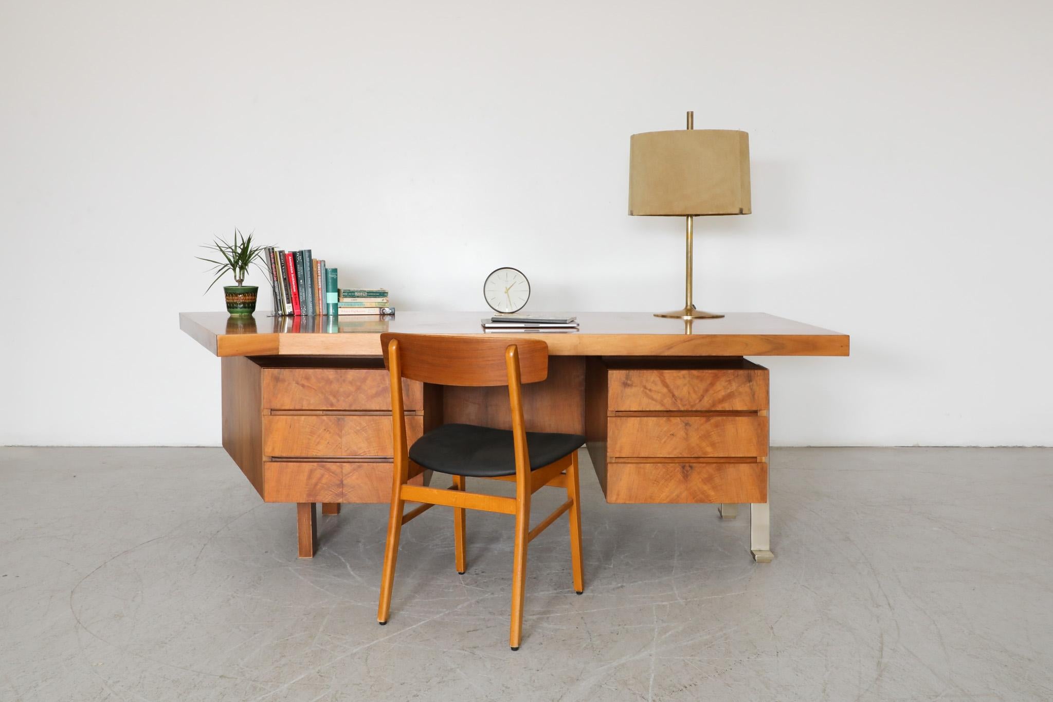 Handsome, Mid-Century, most likely custom made Executive desk with flat faced drawers and uniquely angled top. One side has aluminum legs in a similar design to Poul Kjaerholm's style, the other side is supported by 2 chunky wood legs, privacy