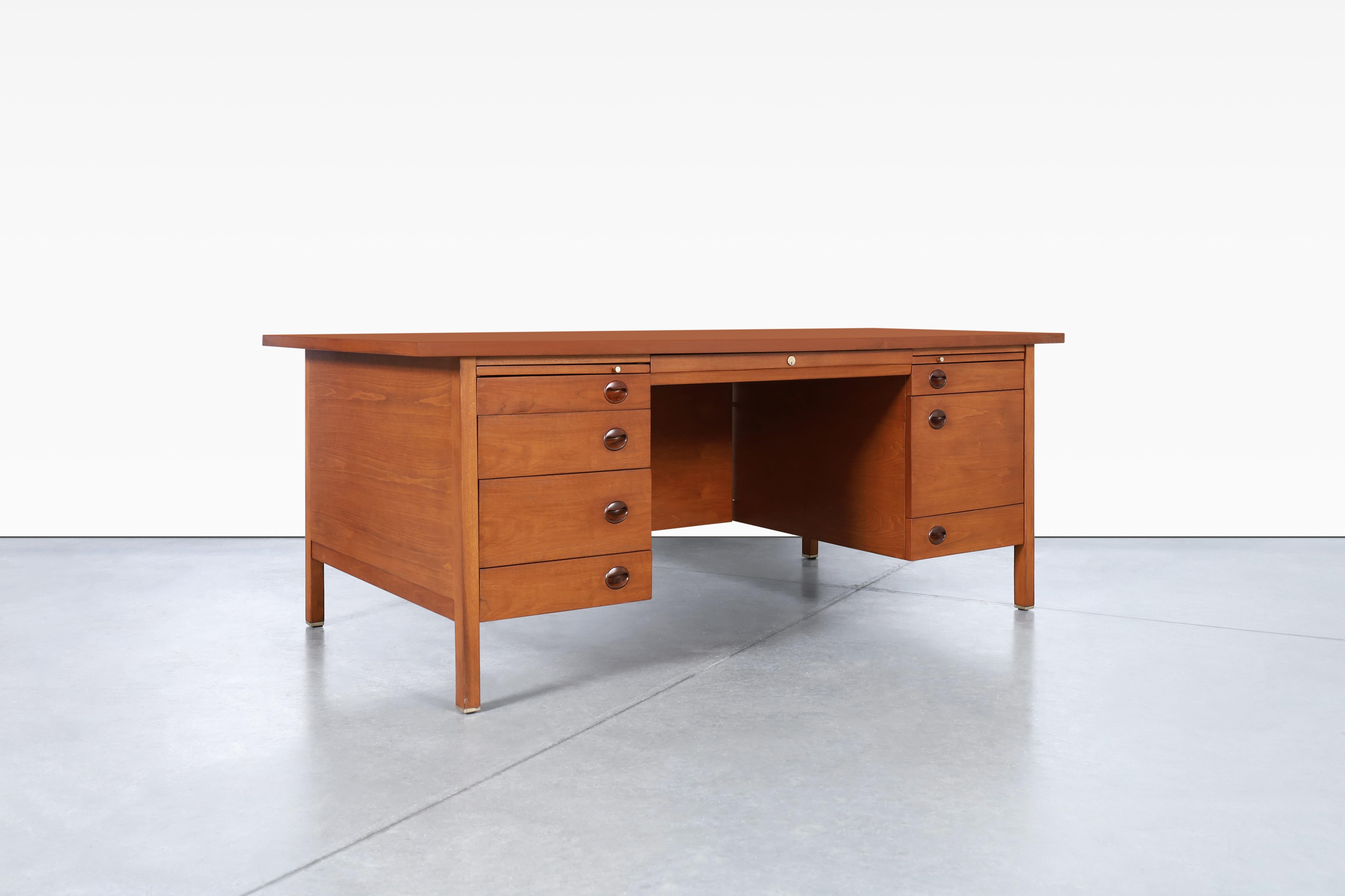 Wonderful mid-century executive walnut desk designed by Edward J. Wormley for Dunbar in the United States, circa 1950s. This desk is made with a timeless design that has been professionally refinished, restoring it to its original glory. Crafted