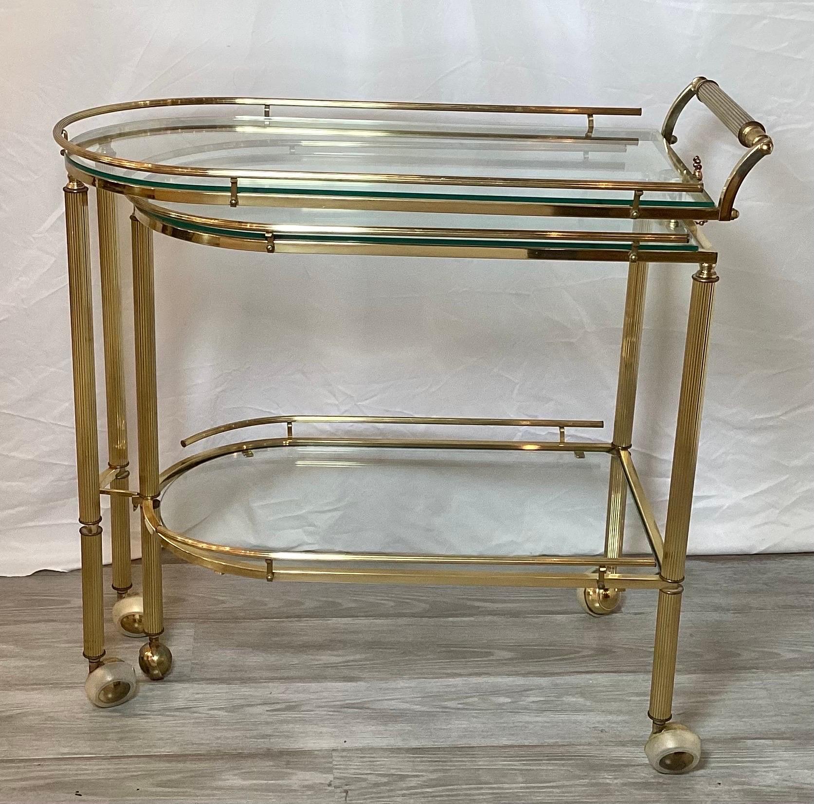 Great expandable mid-century brass bar or serving cart. With a swing out section that gives three shelves for plenty of surface space.