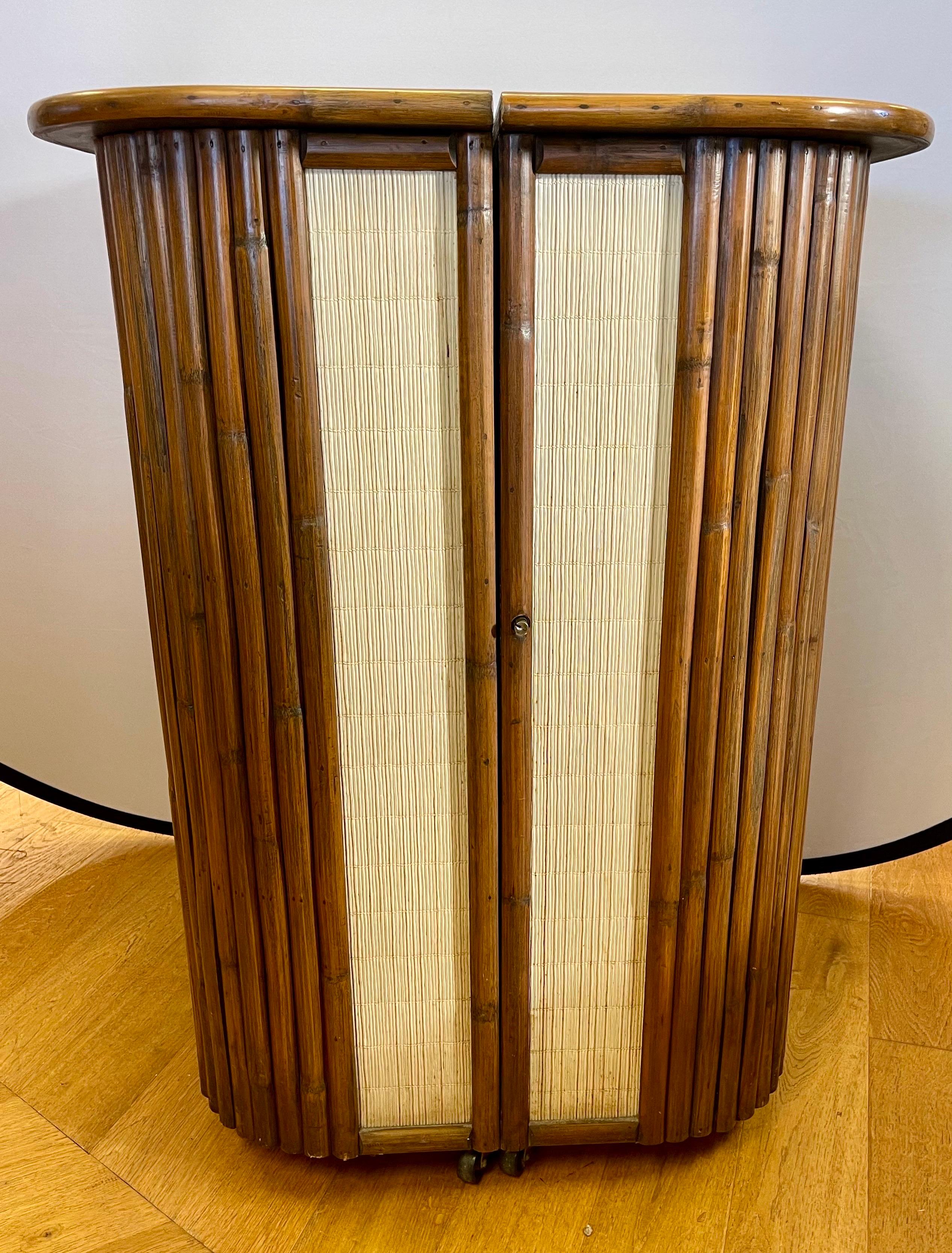 Coveted and ultra rare pencil bamboo expandable rolling bar cart.
All dimensions are above but when the piece is fully open, it measures
four feet in width. Great for parties! Features plenty of storage inside as well as a cutting board that goes up