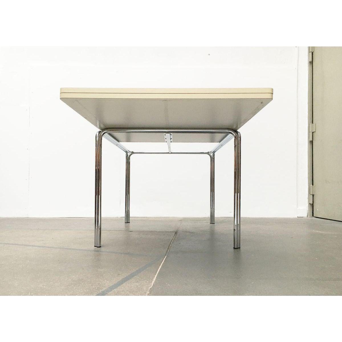 Table de salle à manger extensible des fabricants renommés Läsko Studio Form International.

Le design s'inspire des meubles classiques en acier tubulaire du début du 20e siècle.

Le cadre se compose de quatre barres qui sont reliées entre elles. Un