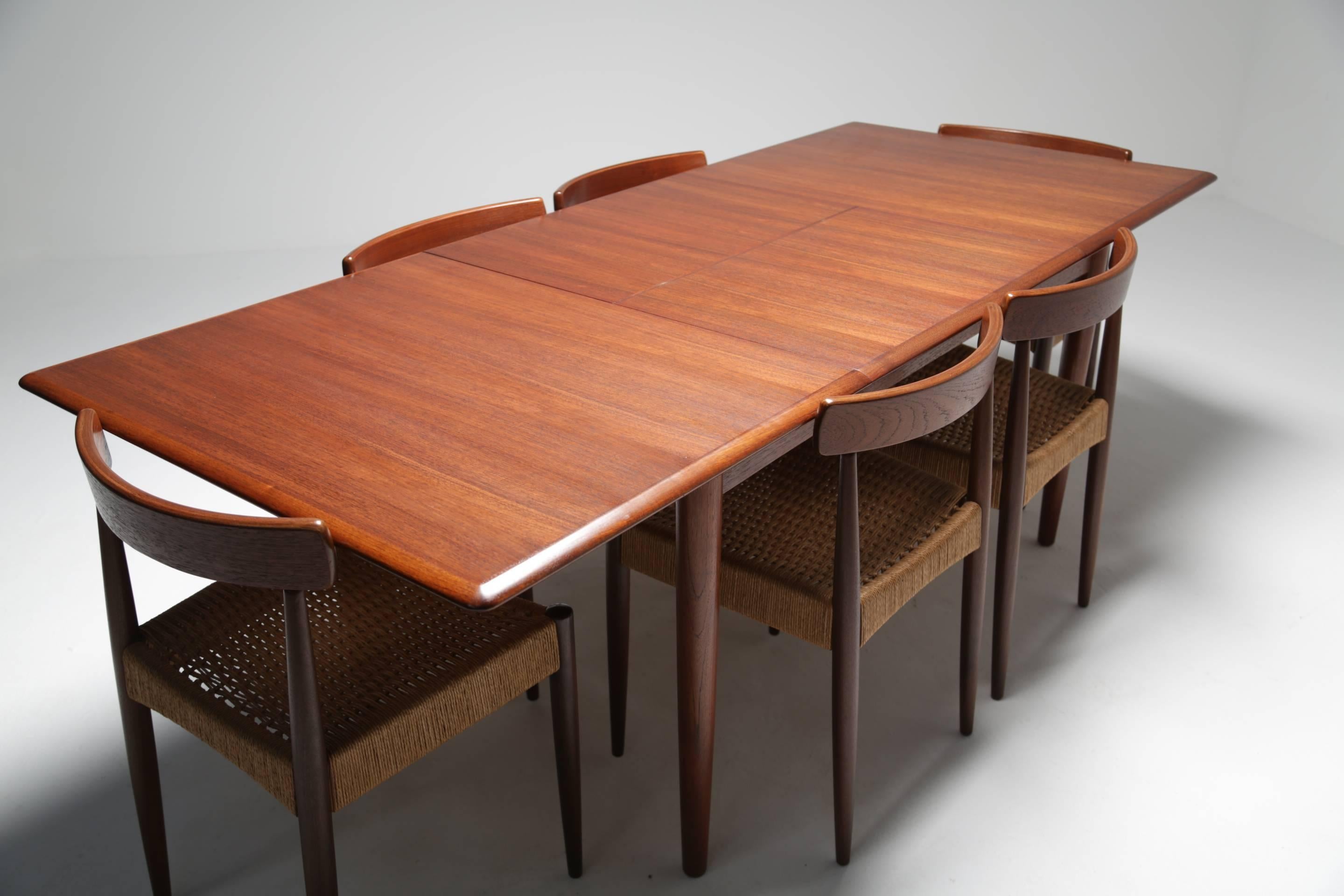 A top quality Danish modern teak dining table by Danish furniture maker Dyrlund.  Excellent manufacture with a large built in butterfly leaf extension which is cleverly folded away internally and can lift the table from a comfortable six seat to 10