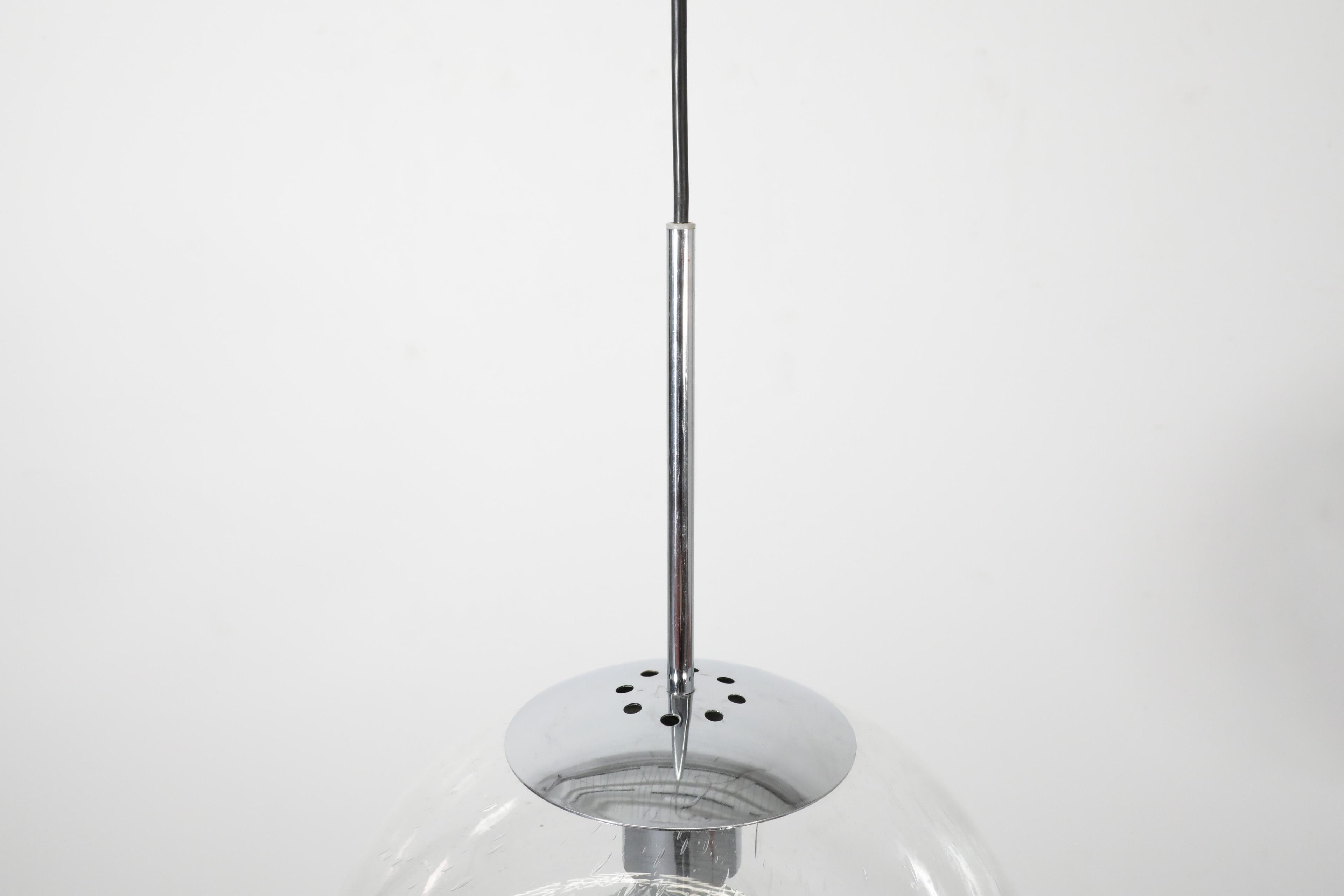 This large, mid-century blown glass globe ceiling light with chrome hardware was manufactured by the trail-blazing Dutch lighting manufacturer Raak.  It features decorative bubble design in glass and handsome chrome hardware. Simple, classic, clean