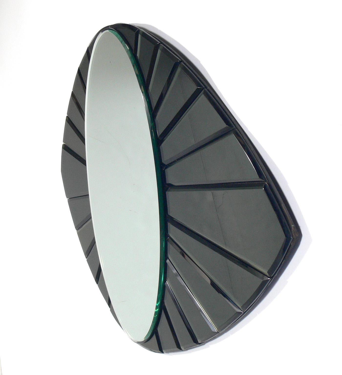 Midcentury eye shape mirror, in the manner of Fontana Arte, circa 1960s. Sculptural form executed in beveled mirror and beveled gun metal color mirror.
