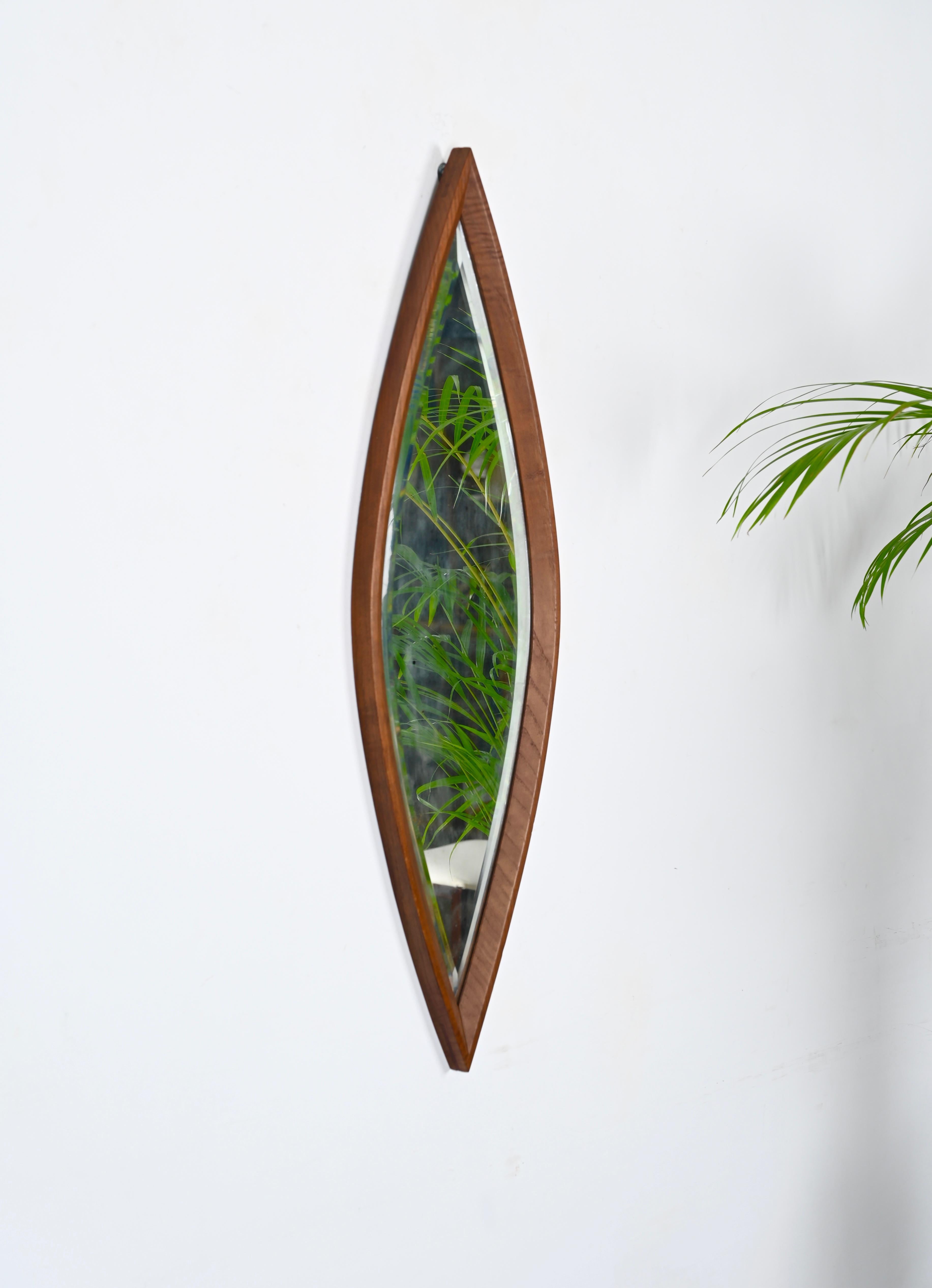 Gorgeous eye-shaped mirror designed in Italy during the 1950s.

This beautiful mirror features and an eye-shaped frame in walnut wood with a stunning beveled mirror inside. The mirror has a protective cover in wood on the back.

The quality of the