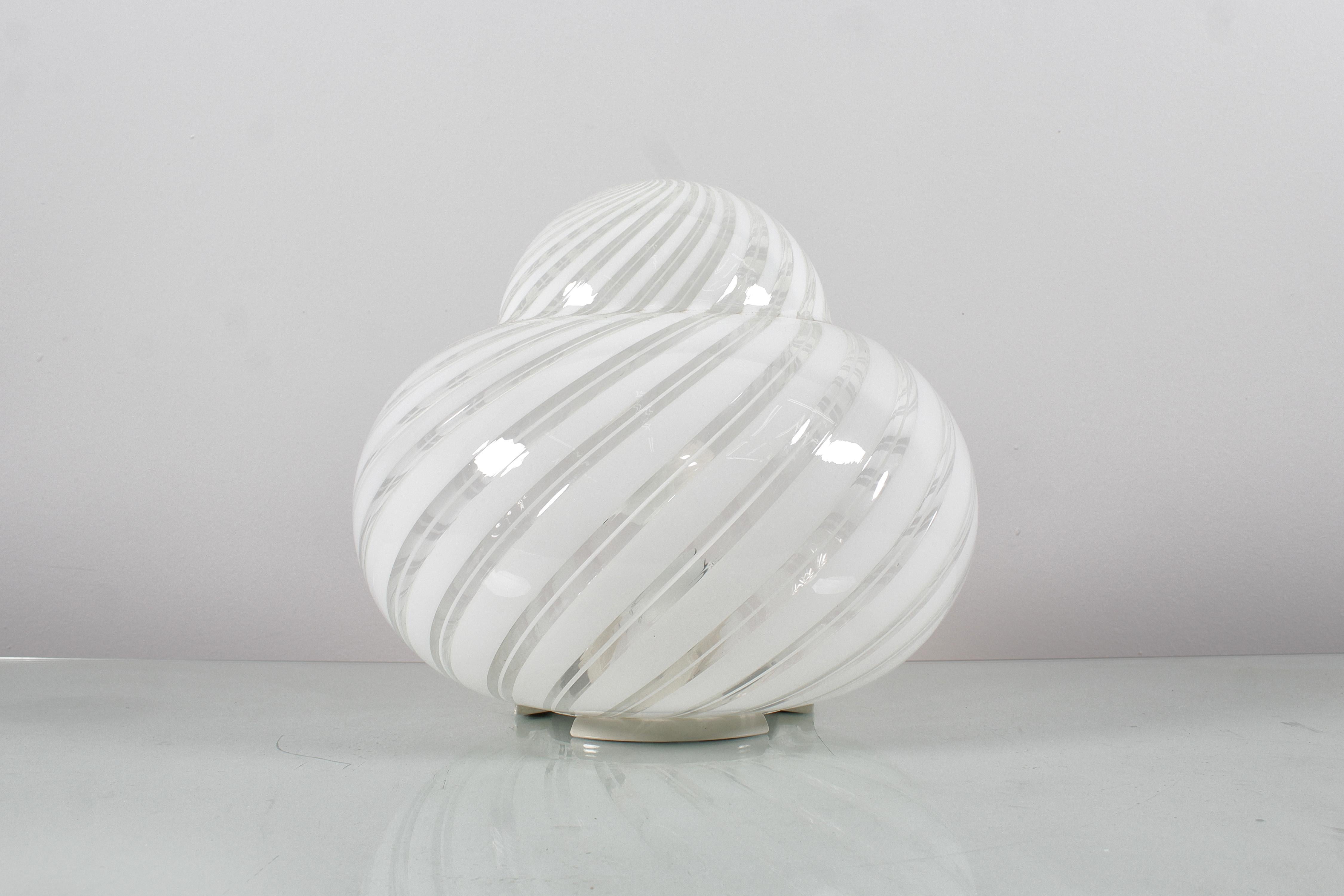 Conjunto de dos lámparas de mesa de cristal de Murano con doble espiral lechosa y metal. Producción italiana de los años 70 de F. Fabbian. Hay una placa con la marca. Desgaste propio de la edad y el uso

cm 20xØ20 (pequeño)
cm 30xØ34 (grande)