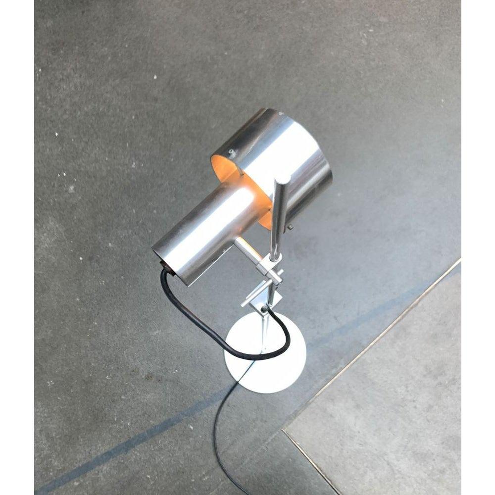 Rara lampada a stelo di Architectural Lighting su progetto del noto designer industriale Peter Nelson degli anni Sessanta.

Il linguaggio e la materialità dei progetti di Nelson riflettono il suo background nell'industria dell'aviazione. L'alluminio