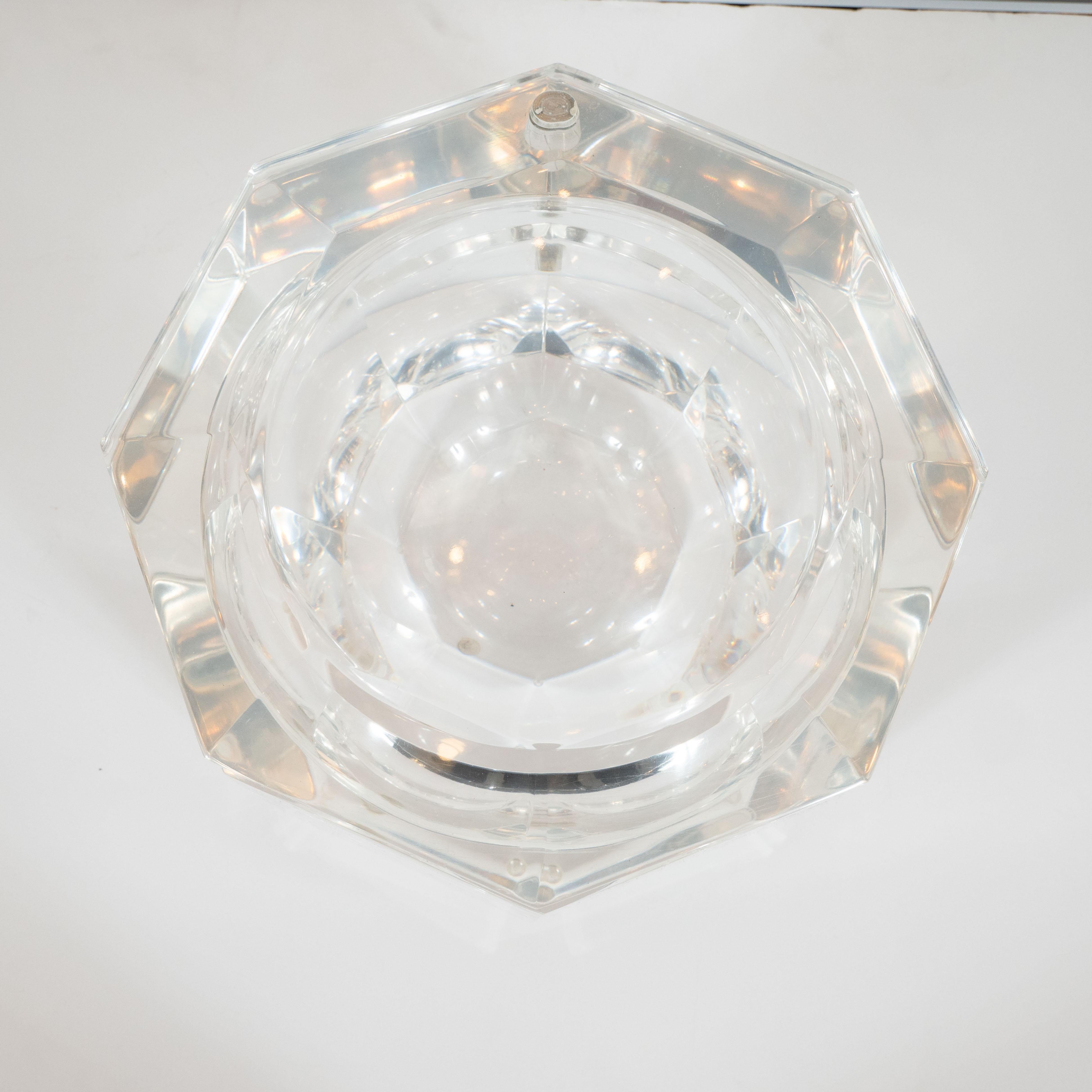 This elegant Mid-Century Modern octagonal ice bucket was realized in the United States by the esteemed designer Carol Stupell, circa 1970. It features a faceted body and top composed of faceted translucent Lucite, giving it the overall appearance of