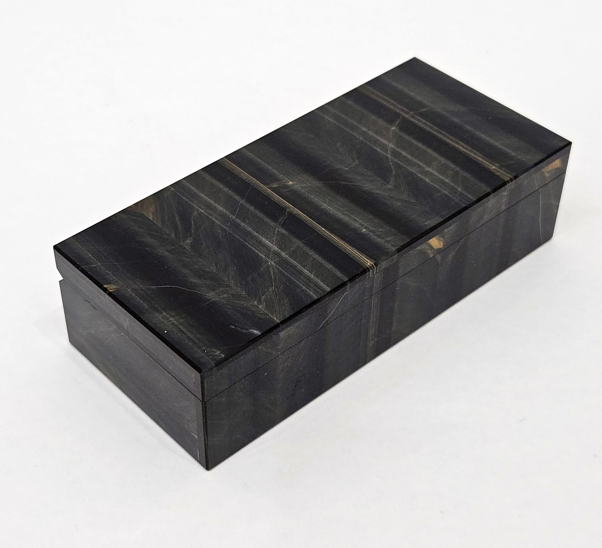 Une exquise boîte vintage en intarsia plaquée de quartz œil de faucon, fabriquée en Italie, c.I.C. 1960. 

Cette boîte décorative a une belle présence grâce à la couleur bleu-noir profonde et riche de la pierre. 

Il présente un lustre magnifique et