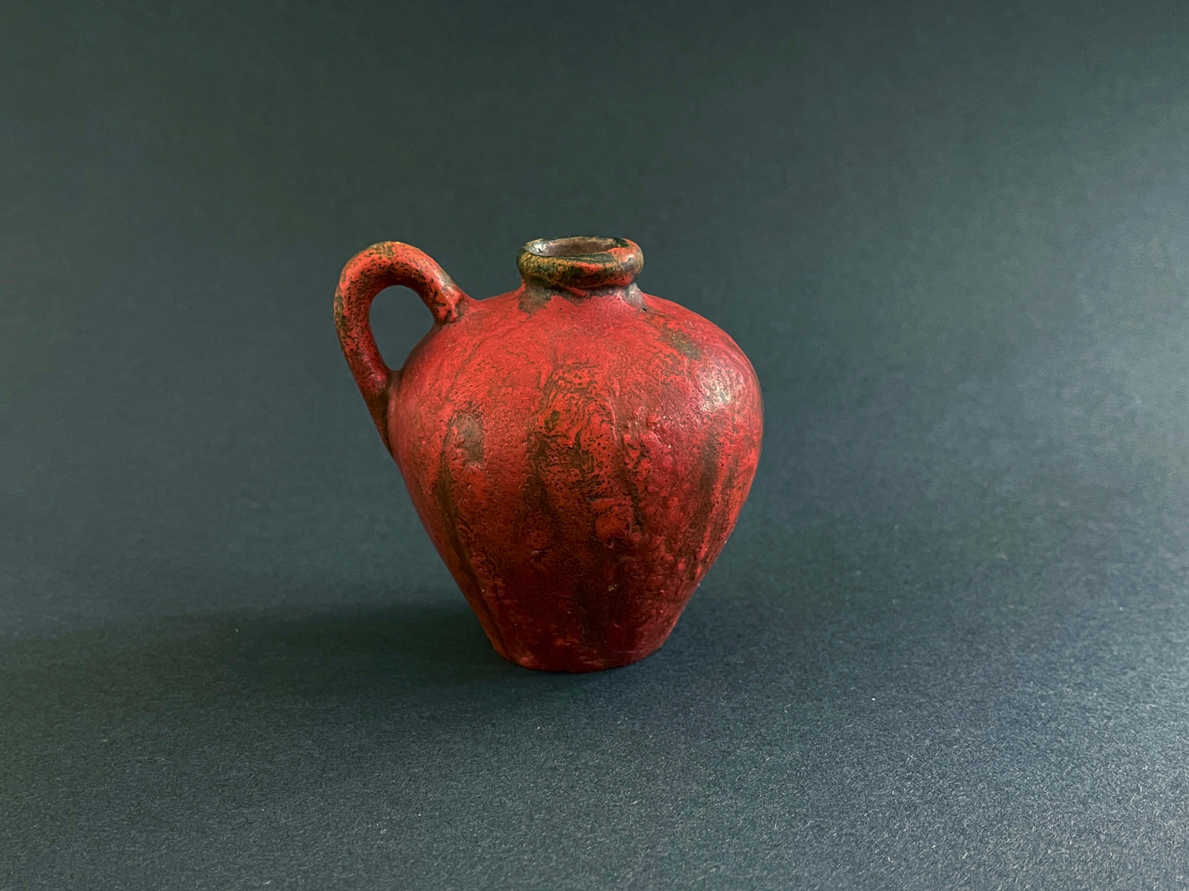 Funky Fat Lava in a lava red: mid-century ceramic vase.
Executed by Kurt Tschörner, around 1960 for Ruscha, Western Germany. 
Lightly bubbly Fat Lava glaze in a more matte medium red.



