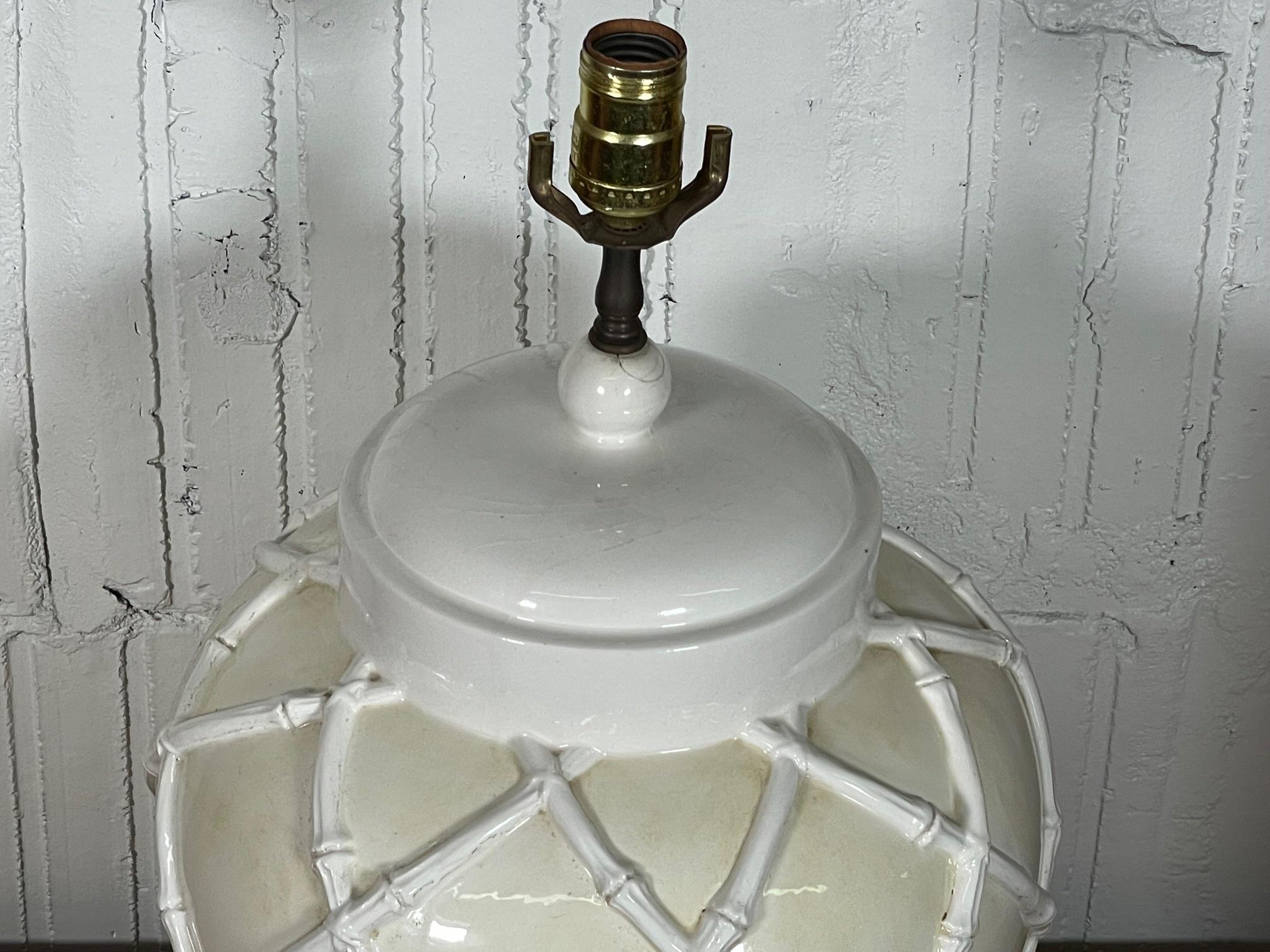 Mid-century ceramic table lamp features faux bamboo detailing and classic ginger jar shape. Good vintage condition with minor imperfections consistent with age. Small repair at top, very solid.