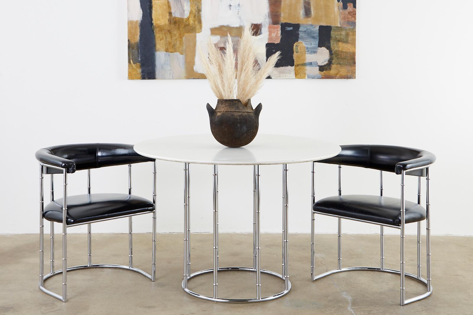 Mid-Century Modern dining table featuring a faux bamboo chrome cage base topped with a laminate Formica round top. The attractive base has eight legs conjoined on top and bottom with round ring stretchers. The round Formica top has a white finish.