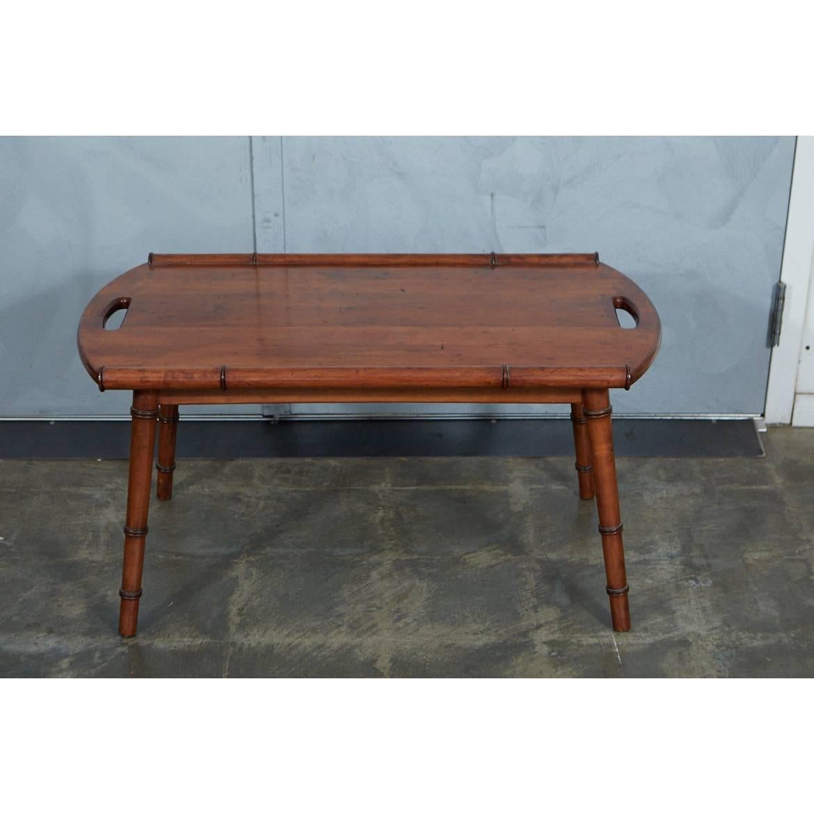 This midcentury faux bamboo tray top coffee table has a fruitwood finish for a wonderful look. The turned, splayed legs have faux bamboo details and the top has two handles.


 