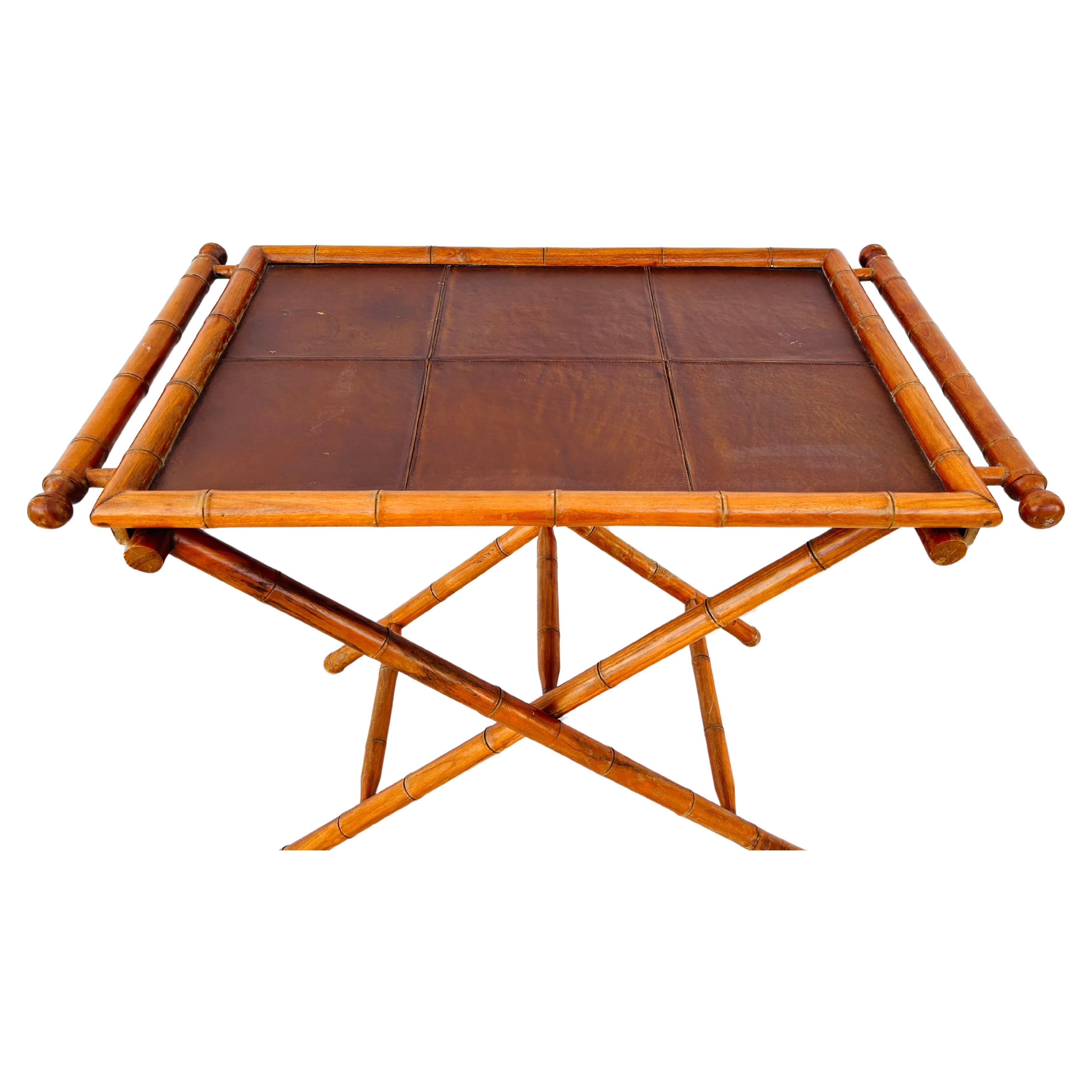 Mid-century modern bamboo rectangular folding serving tray with removable leather insert top. Bamboo handles on either side of tray, along with sturdy leather straps on base. Tray is easily removed for serving purposes. Perfect for serving tea,