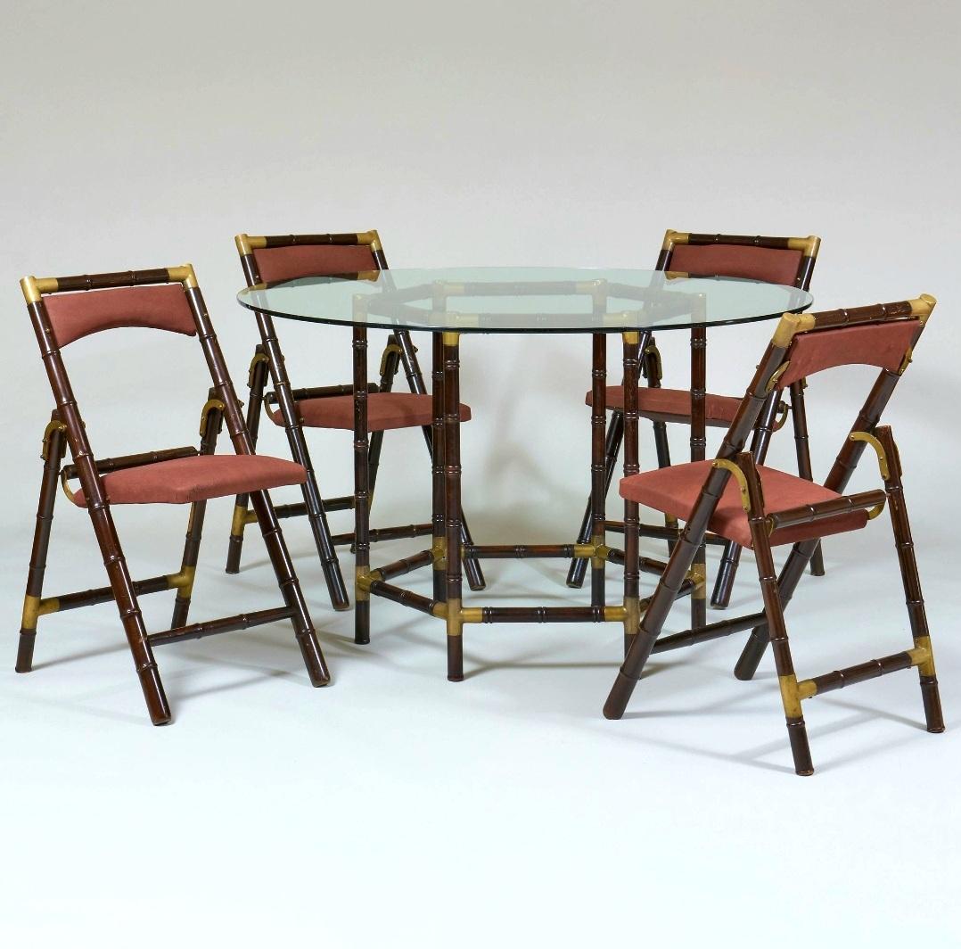 Fabulous mid century modern carved wood in the faux bamboo fashion with heavy brass accents. The four folding chairs and table with glass top are an original condition. Is perfect for a kitchen dining area or as a game stable. In the style of Tony