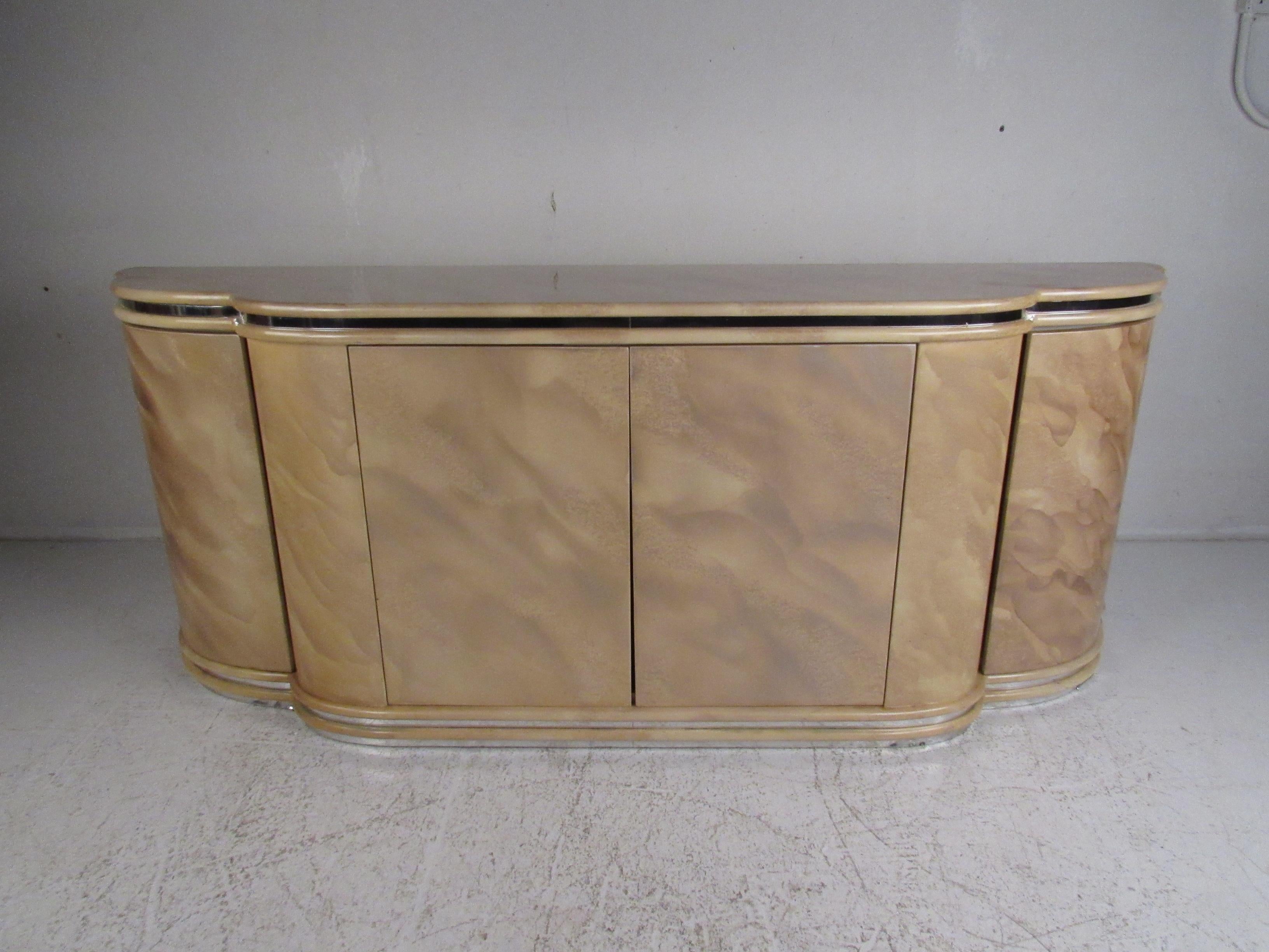 Una splendida credenza moderna vintage con un'esclusiva finitura laccata. Un frontale scolpito con finiture in metallo e un grazioso disegno a fantasia che ne accresce il fascino. Questa bellissima valigetta in stile retrò offre molto spazio per