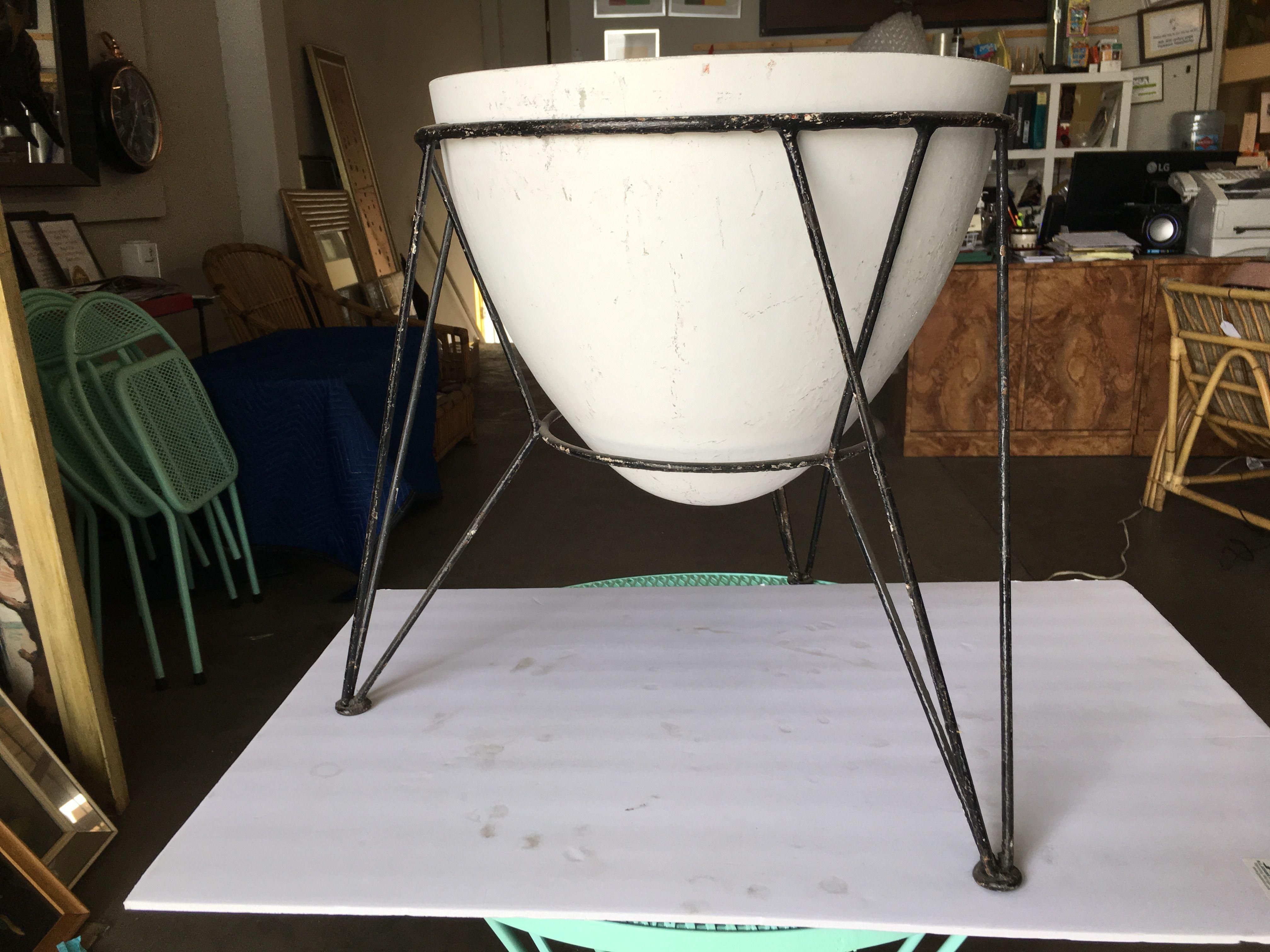 Midcentury fiberglass planter with an egg shape on an iron wire frame tripod style base.