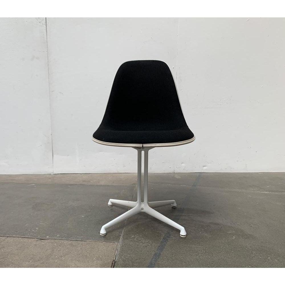 Original Herman Miller Eames Fiberglass Side Chair with black Hopsak and elegant La Fonda Base.

The classic by Ray & Charles Eames. The black Hopsak upholstery is framed with a white keder. The filigree base almost lets the seat shell float on the