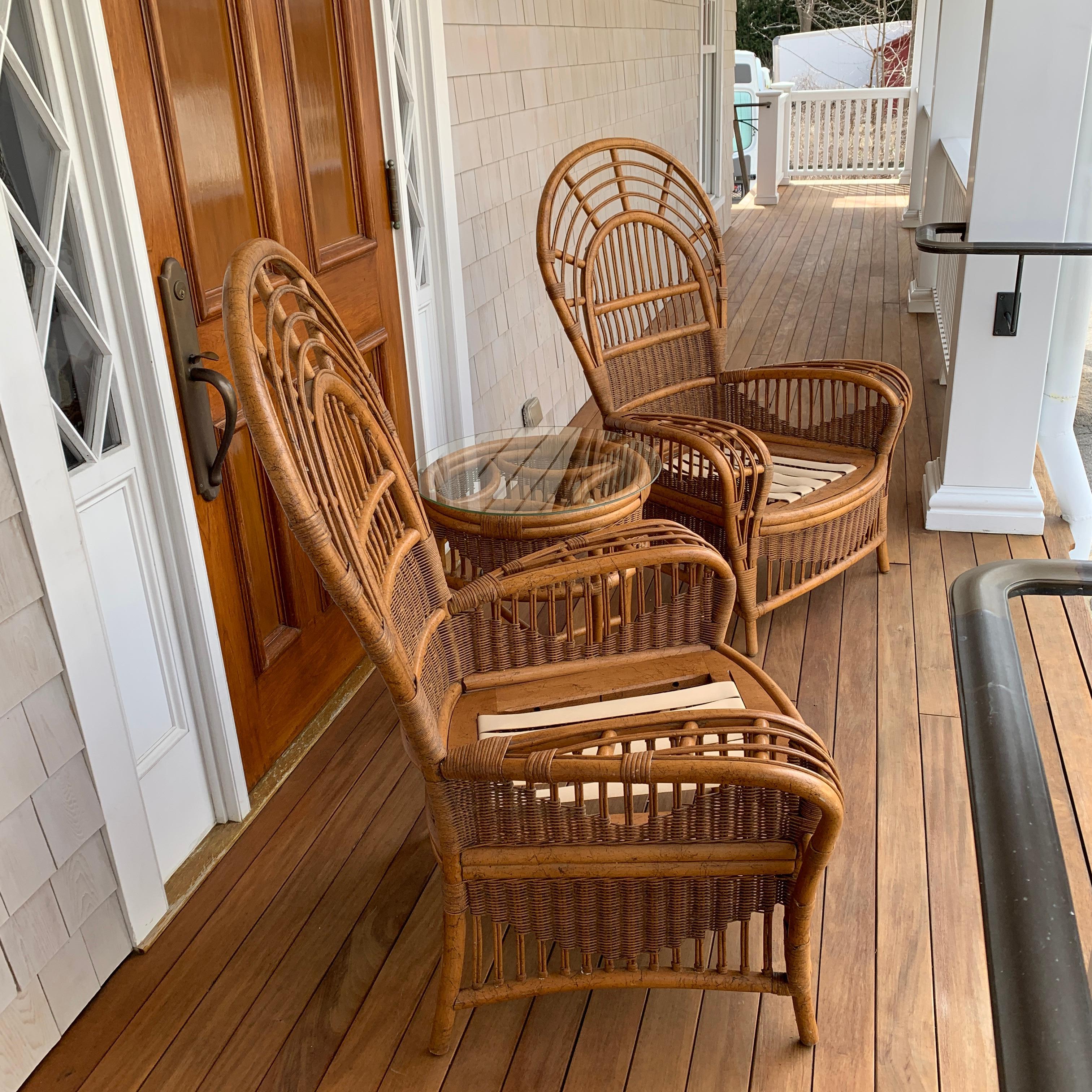 A pair of of Ficks Reed Rattan chairs in original natural finish with matching glass top table. Seat strapping will be replaced before shipment. Chairs measure 48