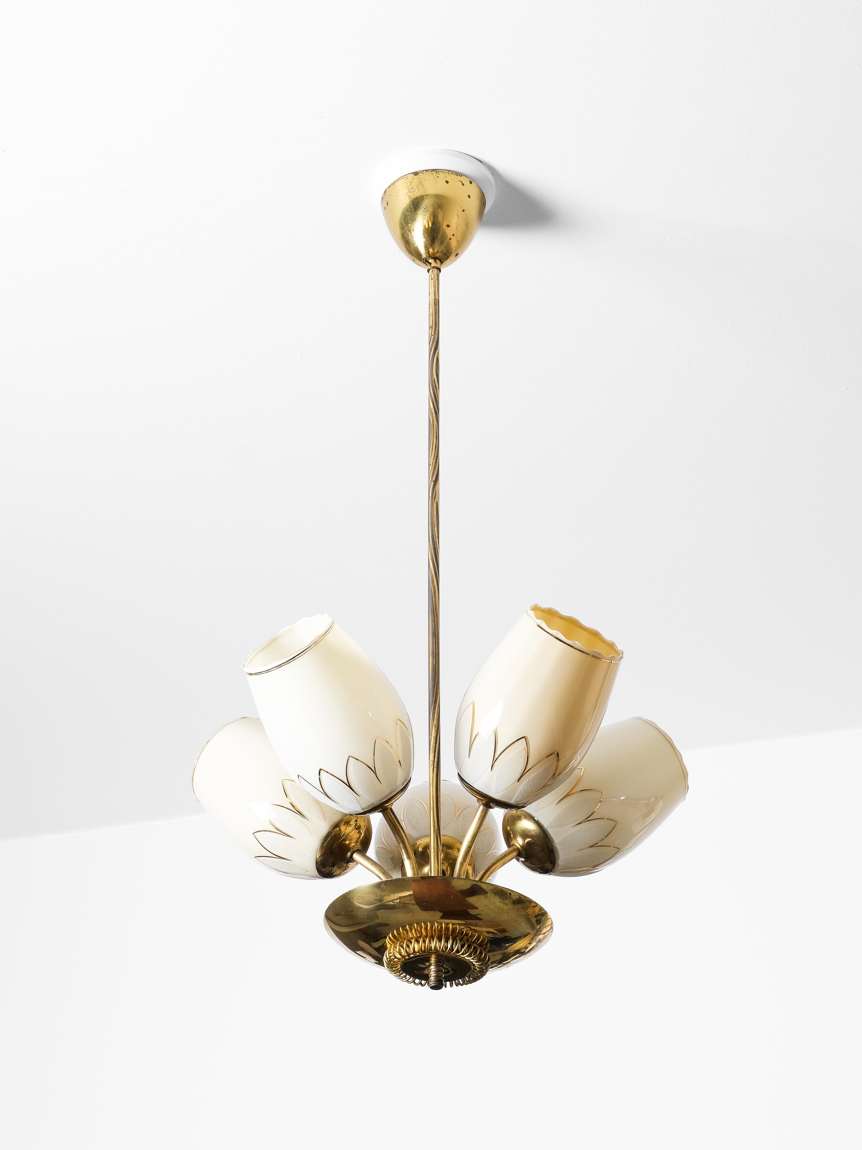 Questo elegante lampadario di metà secolo è stato prodotto da Sievä in Finlandia negli anni '50 ed è un raffinato esempio di design scandinavo. Realizzato in ottone lucido e vetro opalino, il lampadario presenta cinque paralumi a forma di tulipano,