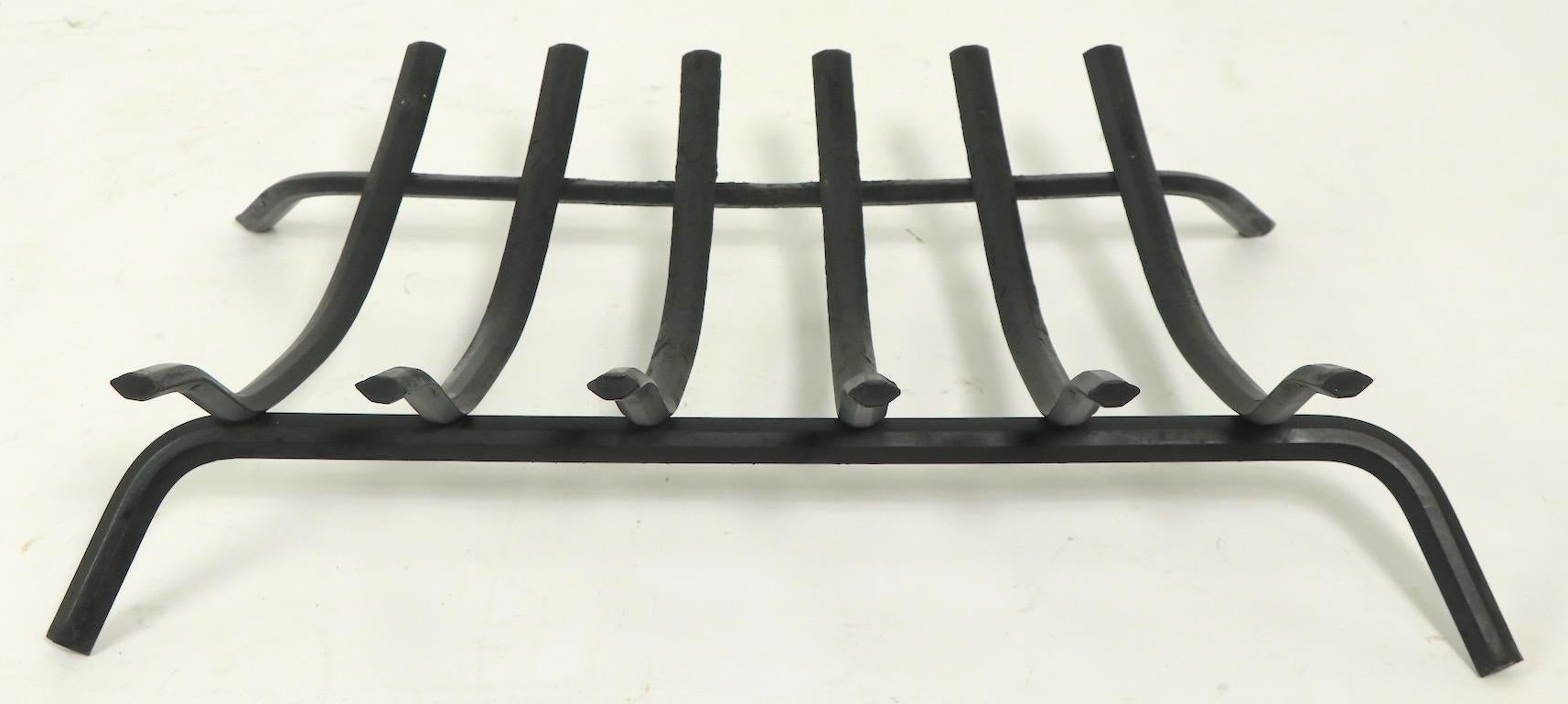 Well made and in very good clean condition, stylized log holder, fireplace grate having six sculpted log supports of solid iron, on two solid iron legs. This example is unusual as the log holder supports have an additional curve making them more
