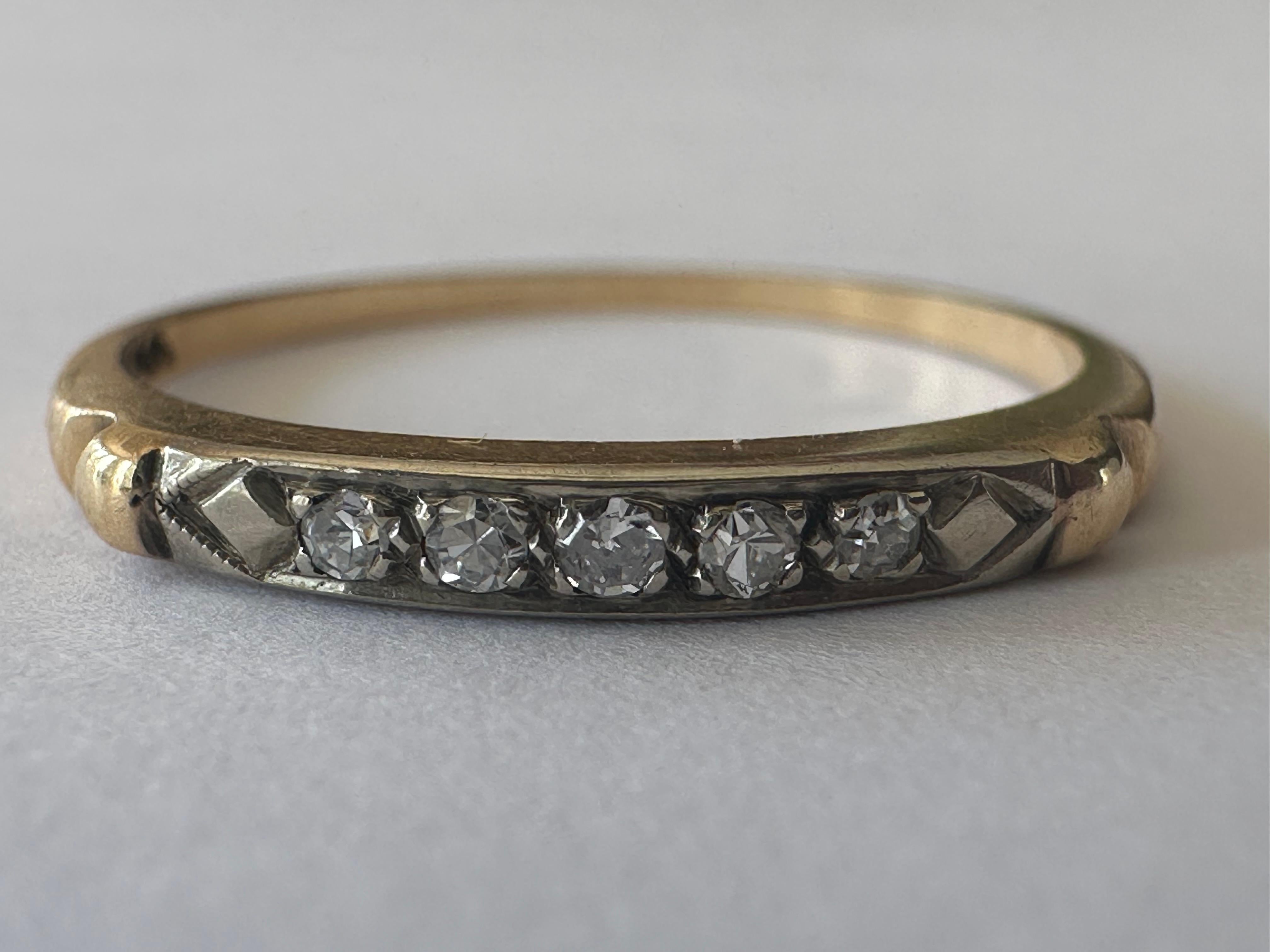 Five single-cut diamonds totaling 0.05 carats H color VS-SI clarity shimmer across the top of this classic mid-century band handcrafted in 14K yellow and white gold. The width of the top of the band measures 2.1mm. 