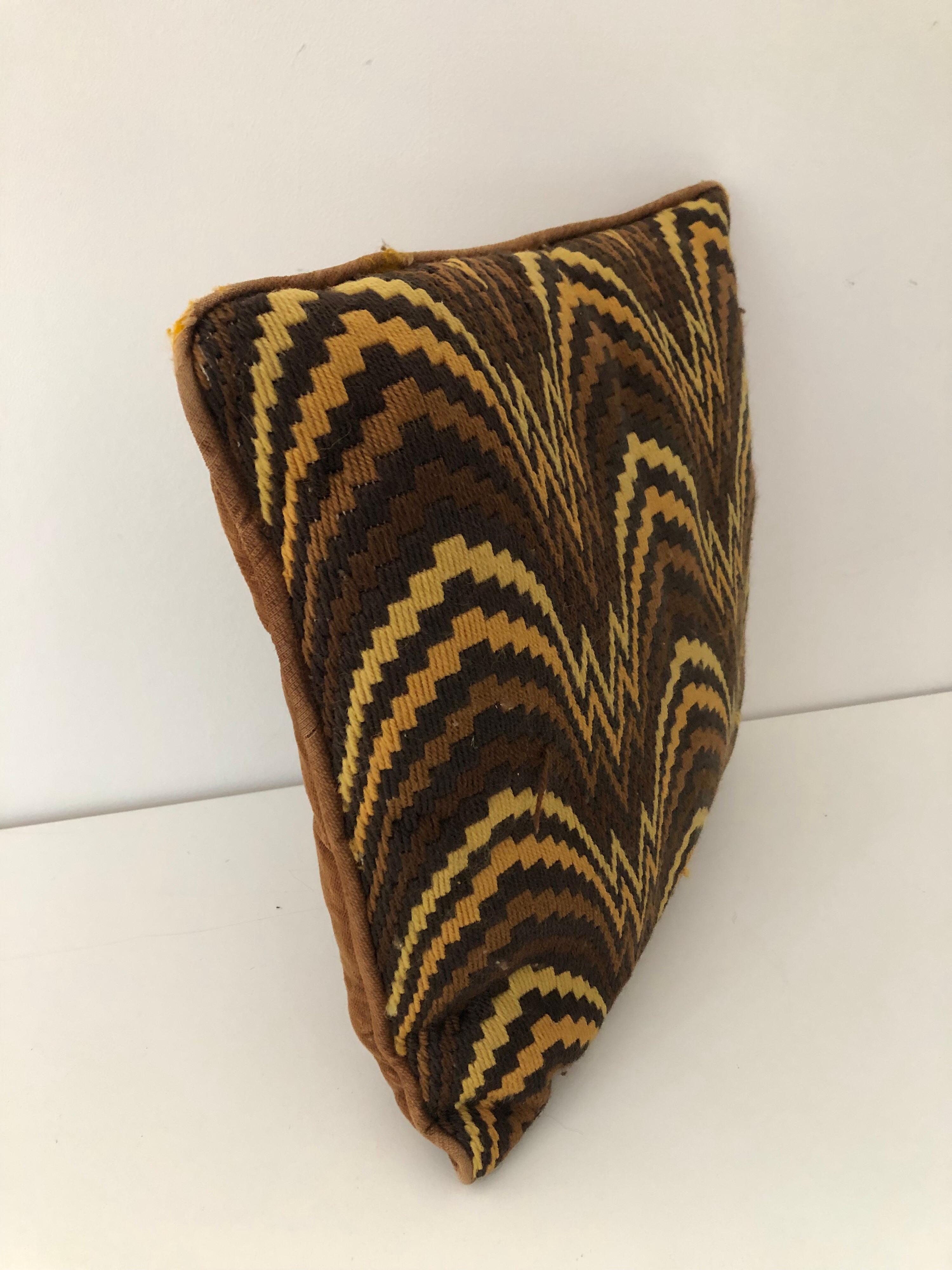 A handmade midcentury flame stitch knit pillow with brown velvet back. Tones of black, brown, mustard, and yellow. Two associated pillows also available.