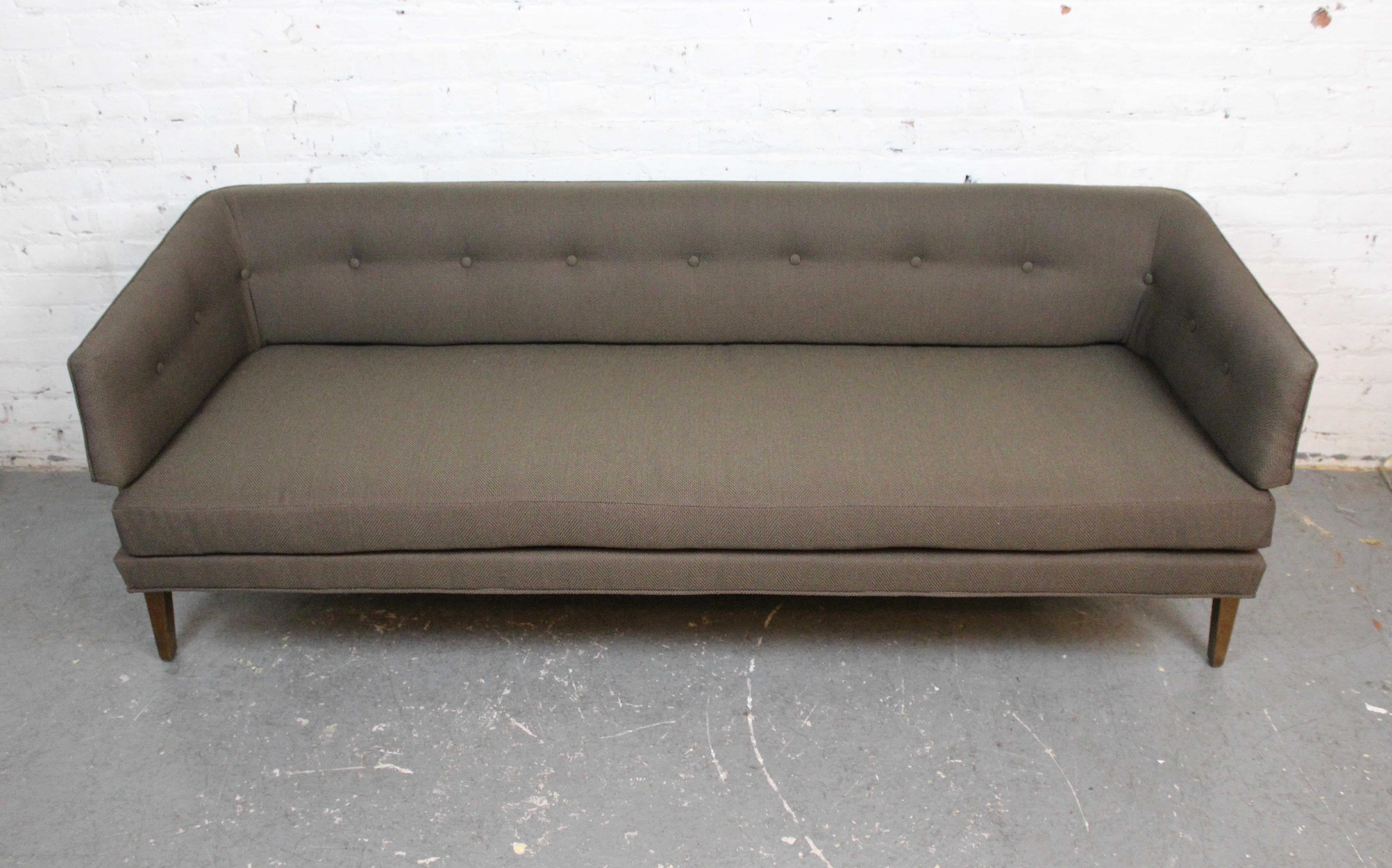Hailing from one of the most iconic partnerships in Mid-20th Century American Modern furniture, this exceptional sofa designed by Edward J. Wormley (1907-1995) and produced by Berne, Indiana’s Dunbar Furniture Company is sure to be a focal point in