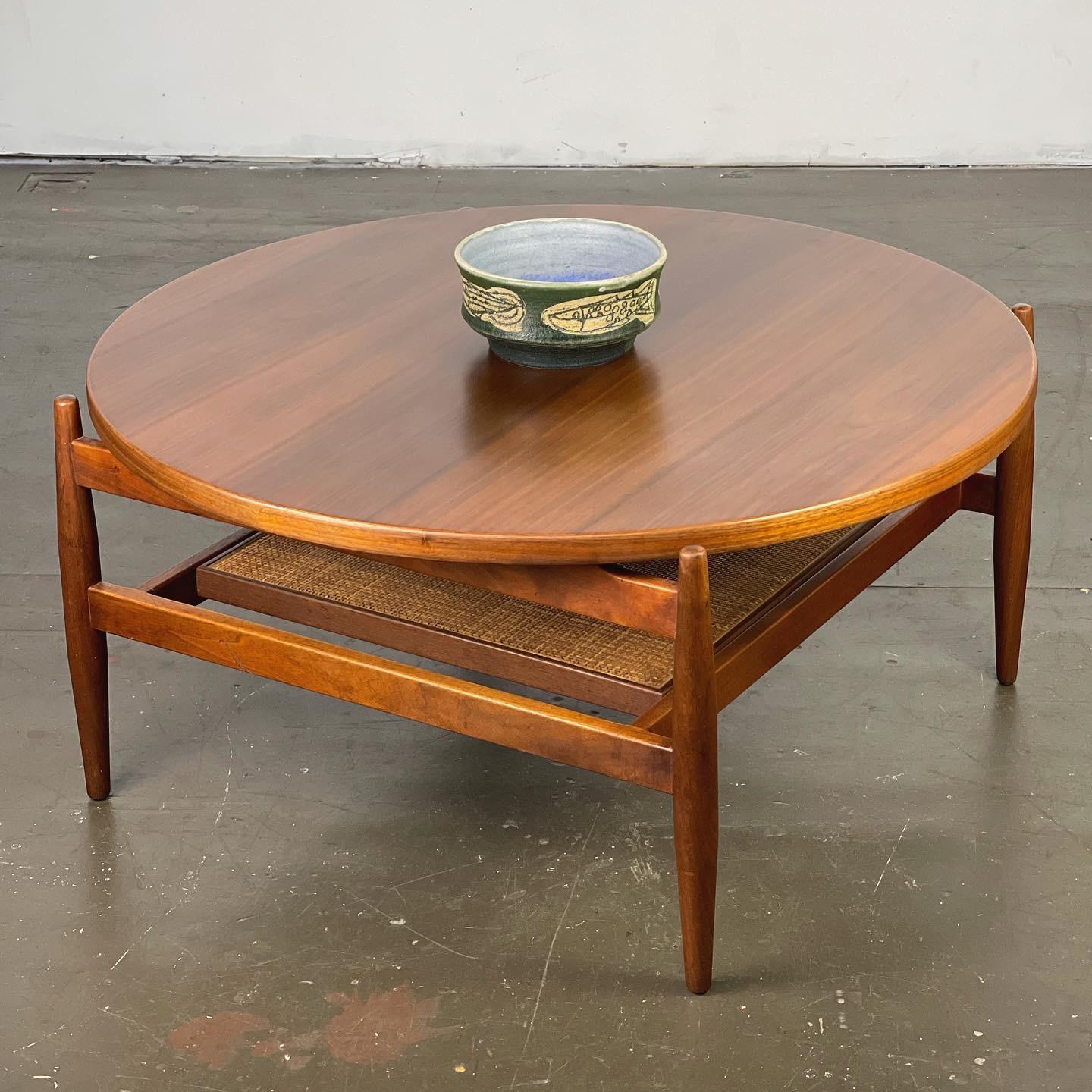 Highly detailed and scarce floating coffee table design by Jens Risom; 1960's. Made of walnut with a cane shelf. 
Restored. 36