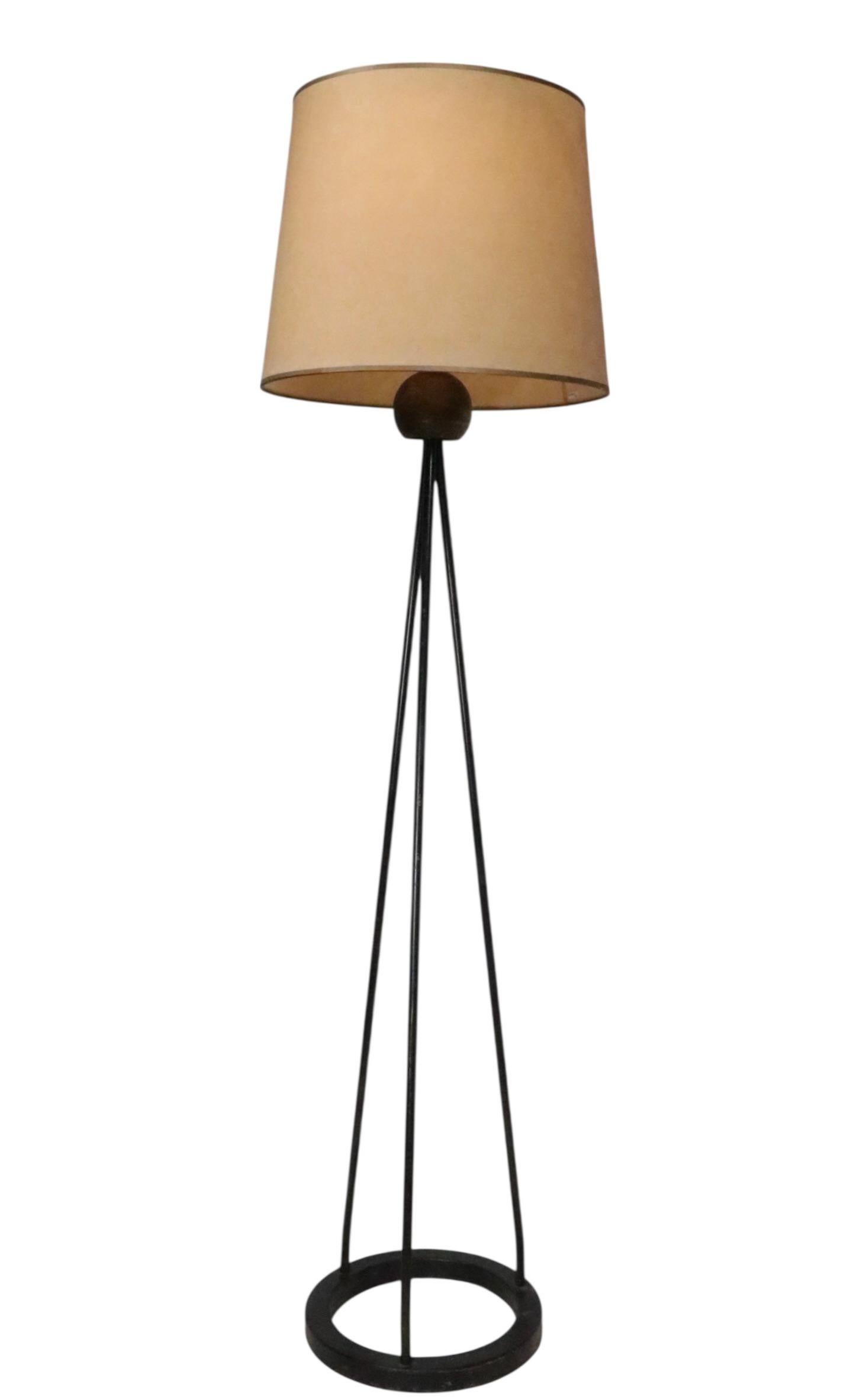 Architectural Mid Century floor lamp designed by Robert Bulmore. The lamp features a conical form base constructed of three  black iron rods, terminating at the top in a brass colored ball.  This example is in very good, original clean, working and